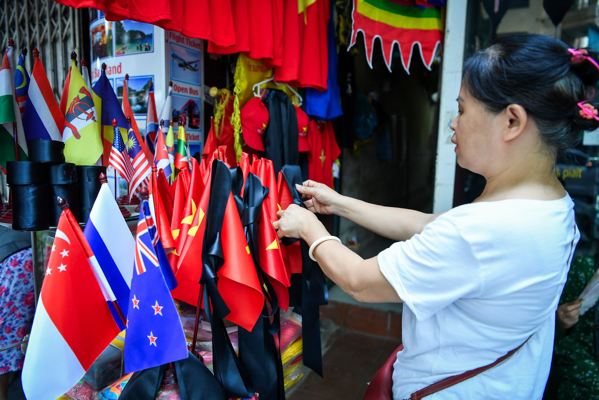 Phố Hàng Bông với nhiều cơ sở kinh doanh đã bày bán cờ với nhiều kích thước cùng dải băng đen phục vụ người dân treo và tưởng niệm cố Tổng Bí thư Nguyễn Phú Trọng trong 2 ngày Quốc tang.