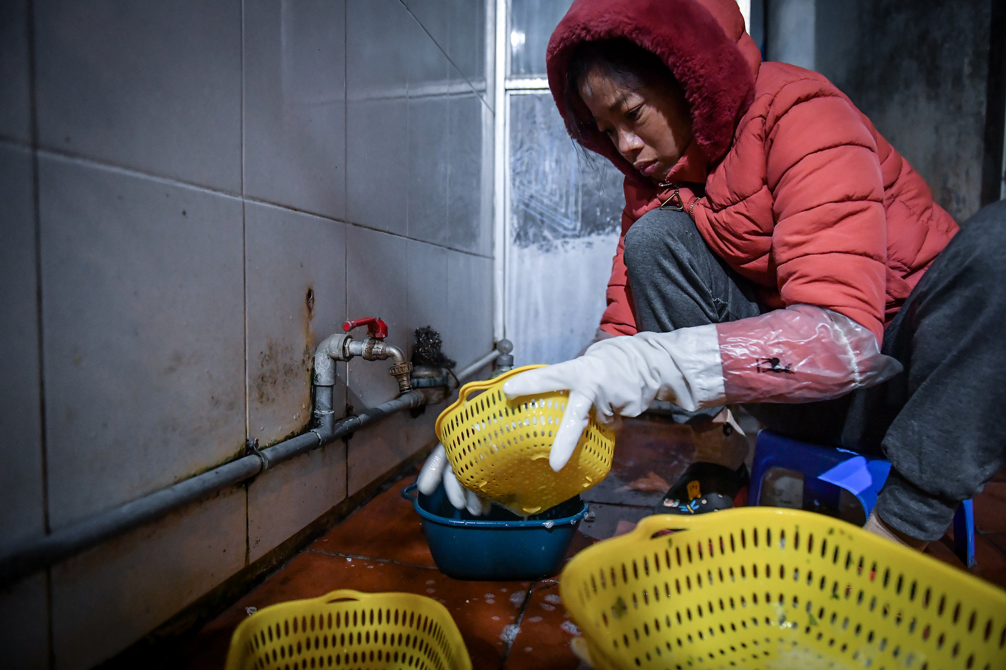 Đi 2 lớp găng tay, nhưng chị Thu vẫn cảm giác "tay như nhúng đá lạnh" khi rửa bát đũa ngoài trời. Ảnh: THÀNH ĐẠT Đi 2 lớp găng tay, nhưng chị Thu vẫn cảm giác "tay như nhúng đá lạnh" khi rửa bát đũa ngoài trời. Ảnh: THÀNH ĐẠT