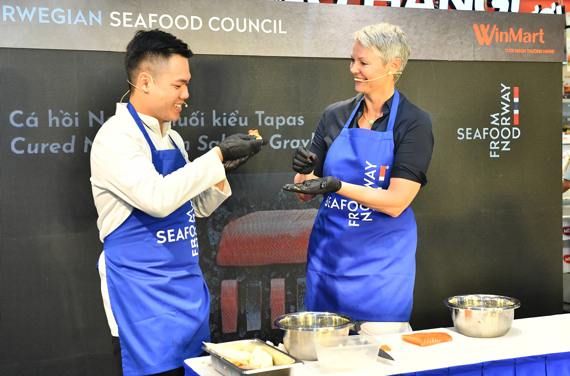 Đại sứ đặc mệnh toàn quyền Vương quốc Na Uy, bà Hilde Solbakken đã cùng đầu bếp chuẩn bị, chế biến món cá hồi Na Uy muối cho khách tham quan thưởng thức. Đại sứ đặc mệnh toàn quyền Vương quốc Na Uy, bà Hilde Solbakken đã cùng đầu bếp chuẩn bị, chế biến món cá hồi Na Uy muối cho khách tham quan thưởng thức.