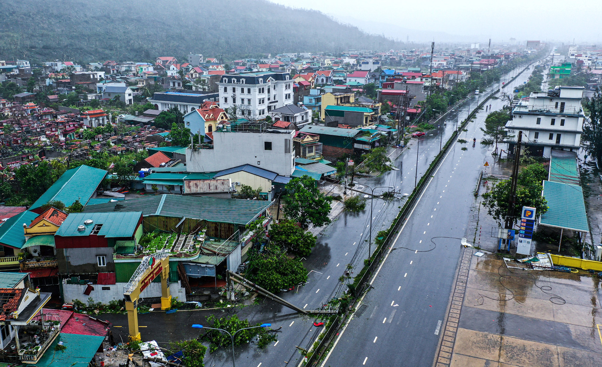Từ góc nhìn khác có thể thấy bão số 3 khủng khiếp như thế nào khi bẻ gãy hàng chục cột điện dài, uốn cong và vắt ngang chúng ra thành những thanh barie chắn ngang Quốc lộ 18 đoạn qua thành phố Cẩm Phả.