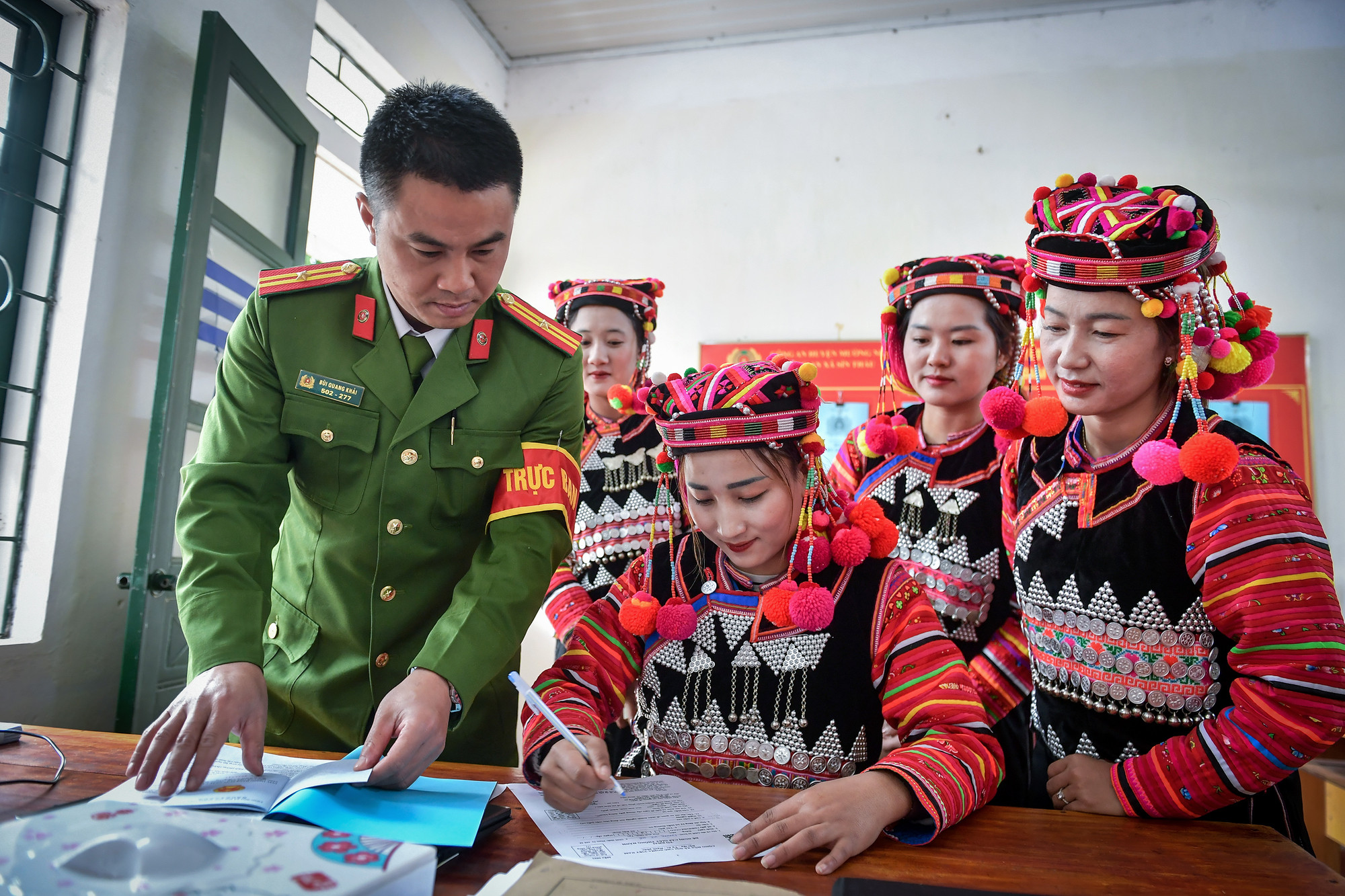 Thiếu tá Bùi Quang Khải hỗ trợ đồng bào dân tộc người Hà Nhì làm các thủ tục hành chính tại trụ sở Công an xã Sín Thầu.