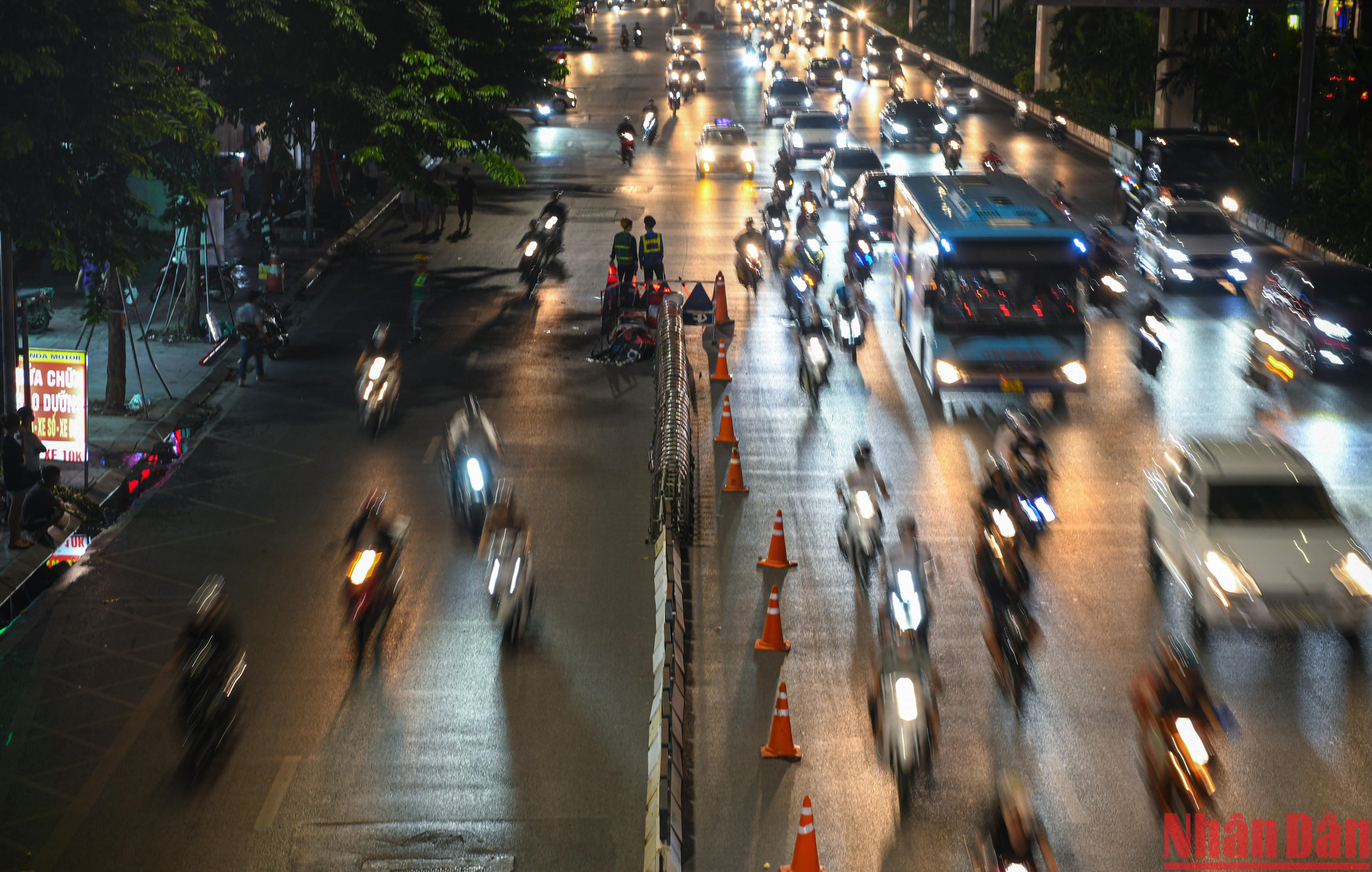 Trời tối, các phương tiện đi qua đây rất khó quan sát dải phân cách mới lắp, luôn phải có người túc trực đứng cầm biển báo đứng hướng dẫn phân làn.