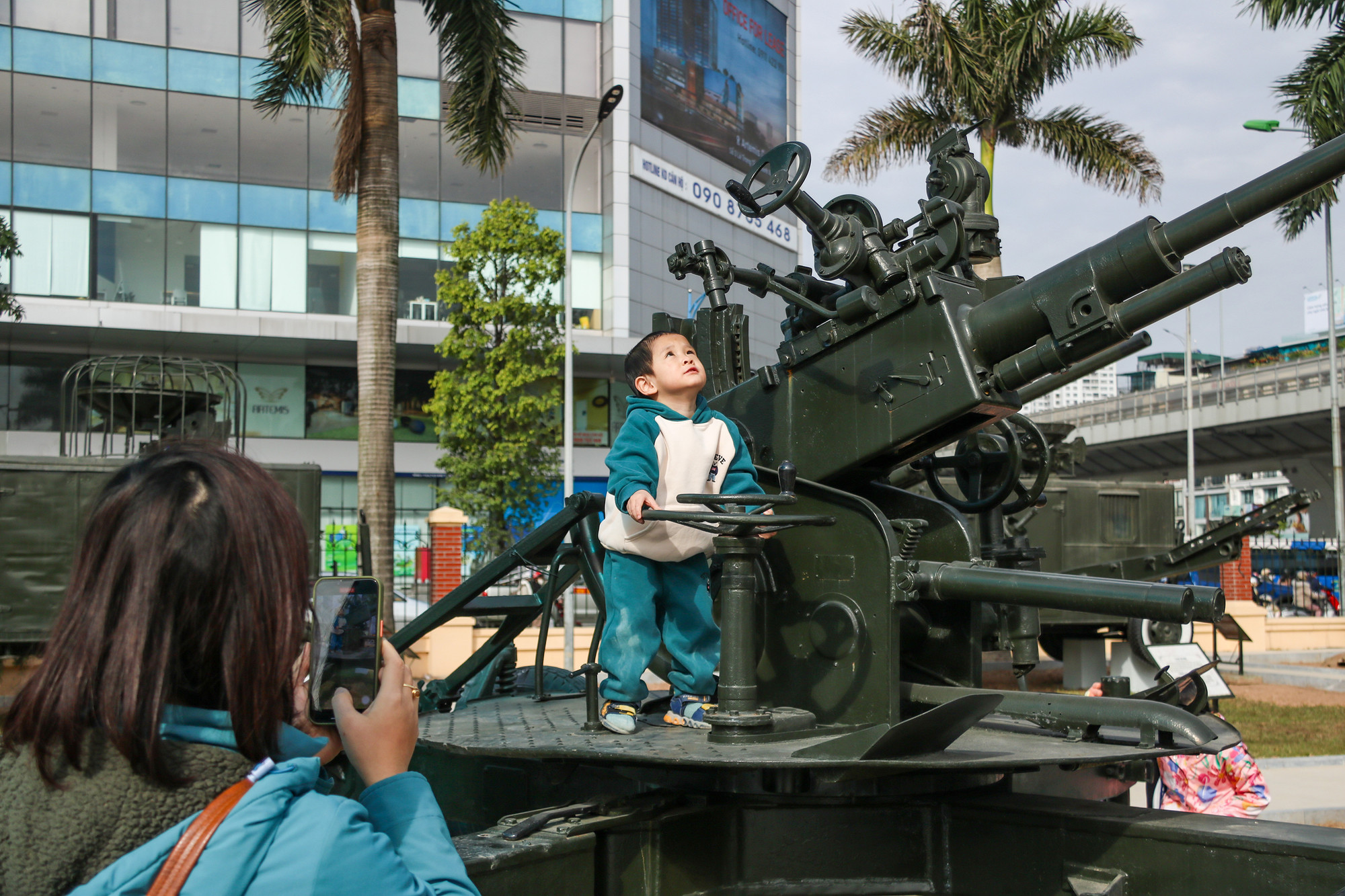 Phụ huynh chụp hình cho con em bên pháo phòng không.