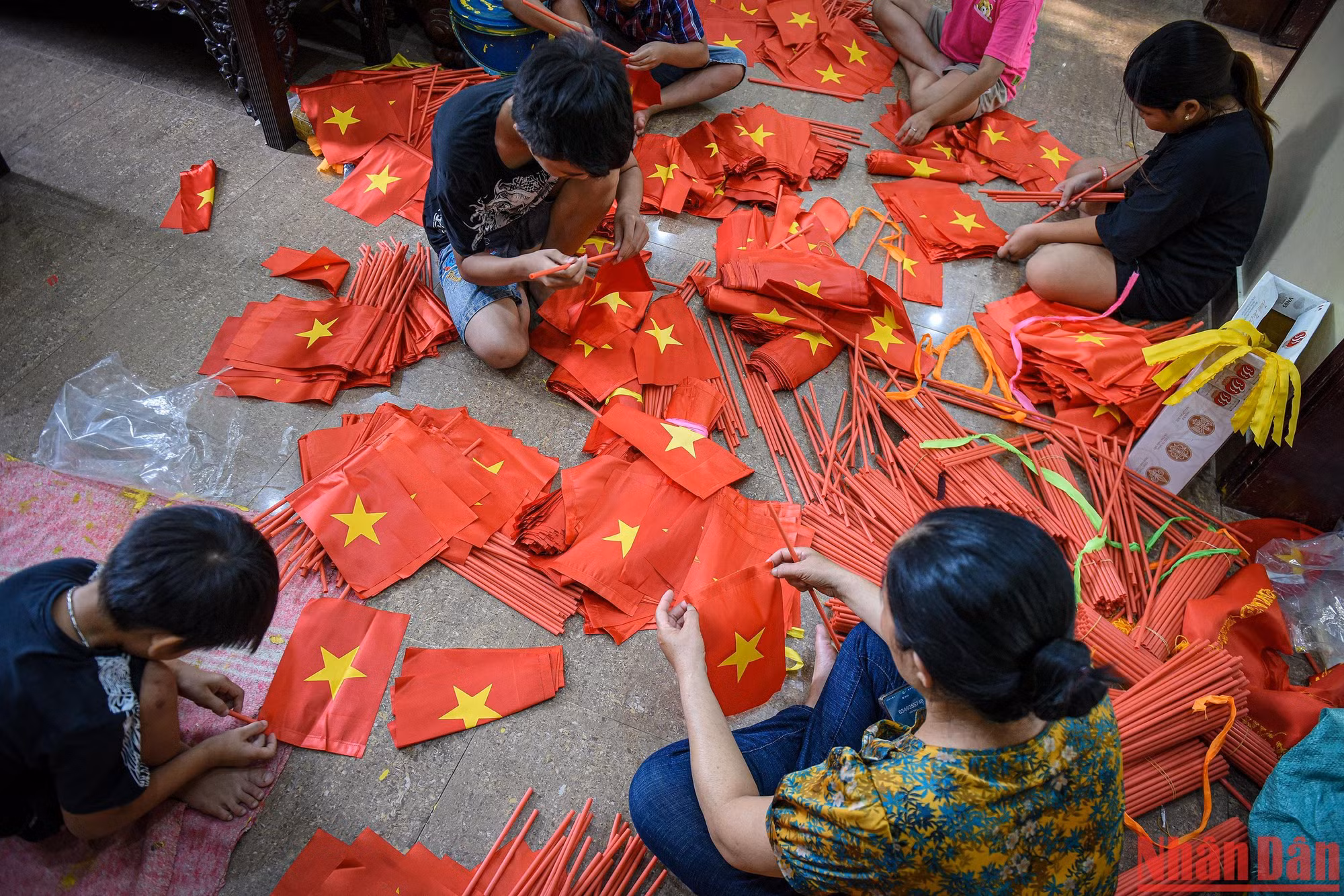 Ngoài thêu cờ chị Nhung còn dạy trẻ con trong làng làm cờ, các em nhỏ đều rất thích thú với công việc bổ ích này.