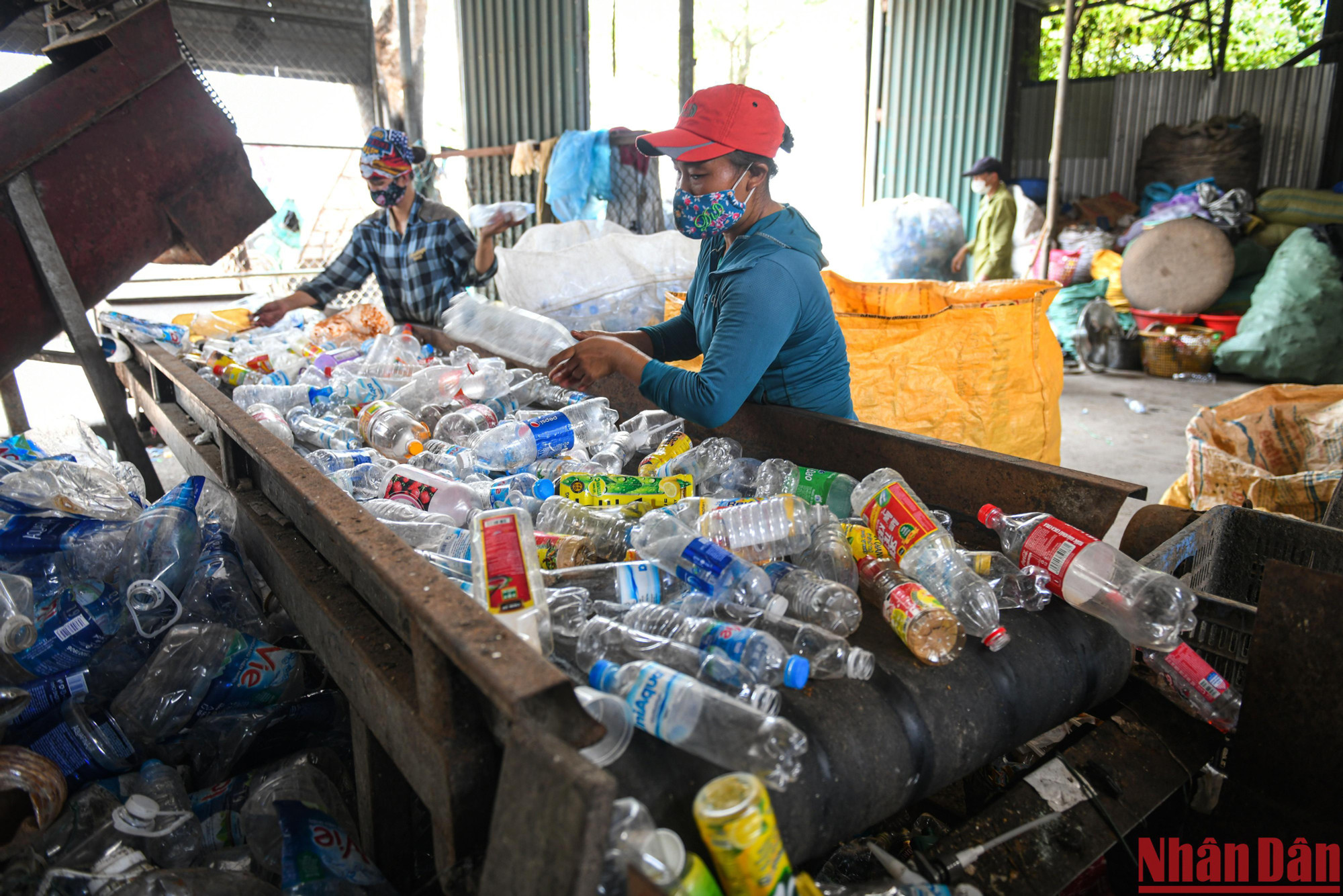 Hai nữ công nhân phân loại chai nhựa trên dây chuyền. Vài năm trở lại đây, hệ thống máy móc cũng được các chủ cơ sở đưa vào sử dụng nhằm nâng cao năng suất lao động.
