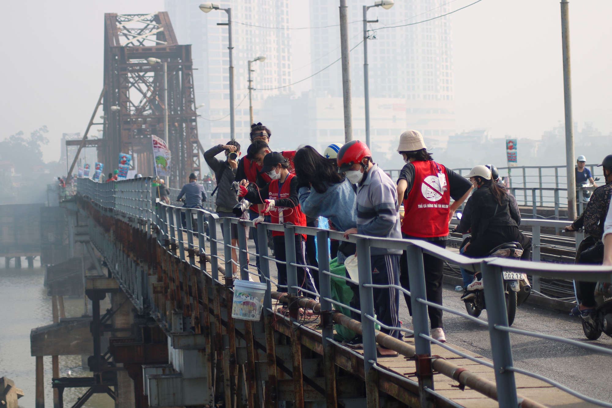 Theo ghi nhận của phóng viên, ngay từ sáng sớm, người dân đã đến các địa điểm quen thuộc ở Hà Nội như cầu Long Biên… để thả cá tiễn ông Công, ông Táo về Trời. Vì vậy, để bảo đảm người dân không thả cả túi nilon xuống sông, nhiều tình nguyện viên đã có mặt từ sớm để giúp người dân thả cá.