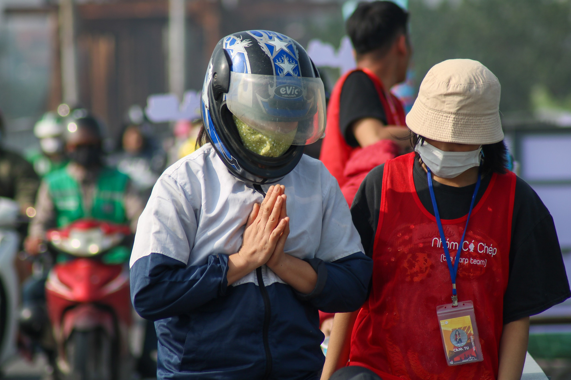 Người dân đứng trên cầu khấn vái sau khi thả cá.