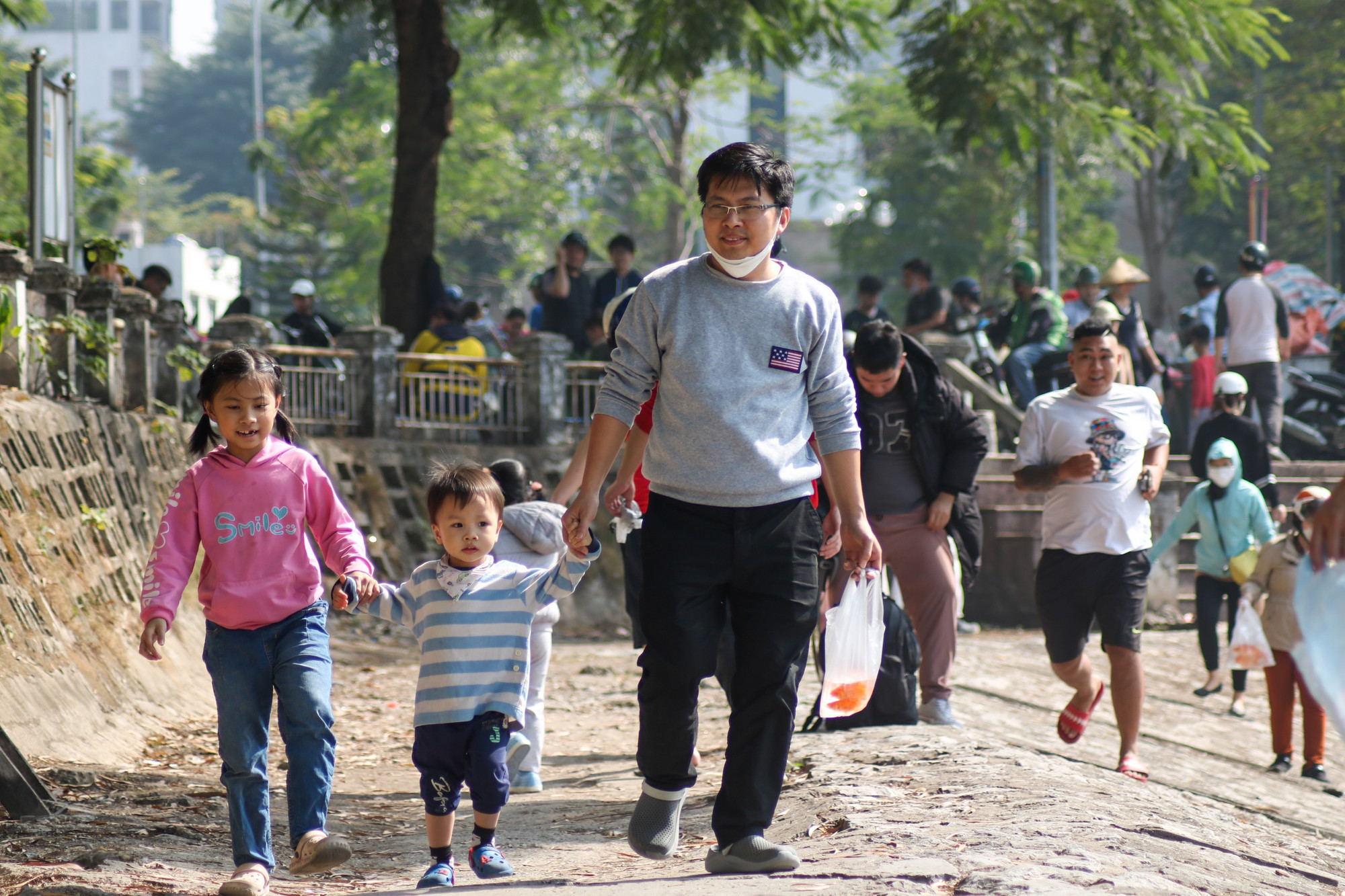 Các bậc phụ huynh đưa con em mình đi cùng, để các con hiểu hơn về ý nghĩa của hoạt động phóng sinh cá chép trong ngày Lễ ông Công ông Táo.