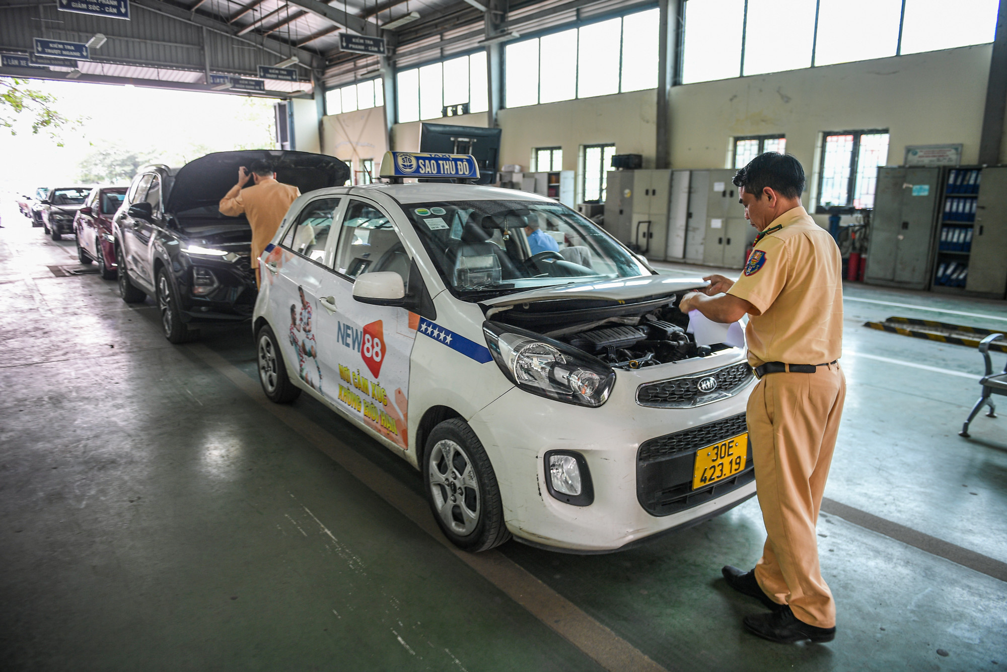 Phía bên trong, các cán bộ, chiến sĩ Cảnh sát giao thông được cử tới đây để tăng hỗ trợ trong hoạt động đăng kiểm đang phối hợp nhịp nhàng với các đăng kiểm viên để thực hiện đăng kiểm phương tiện cho người dân.