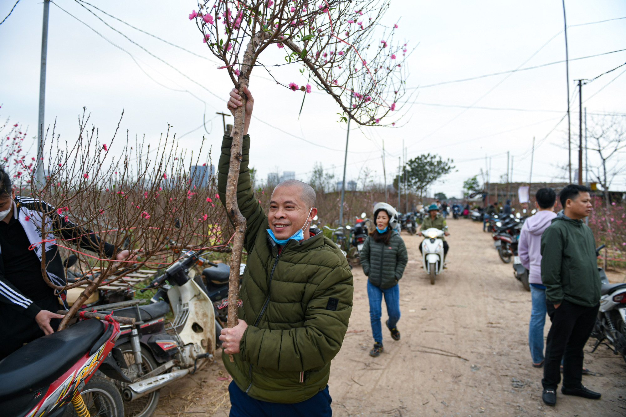 Một người dân không giấu được niềm vui sau khi chọn được cành đào dáng huyền ưng ý.