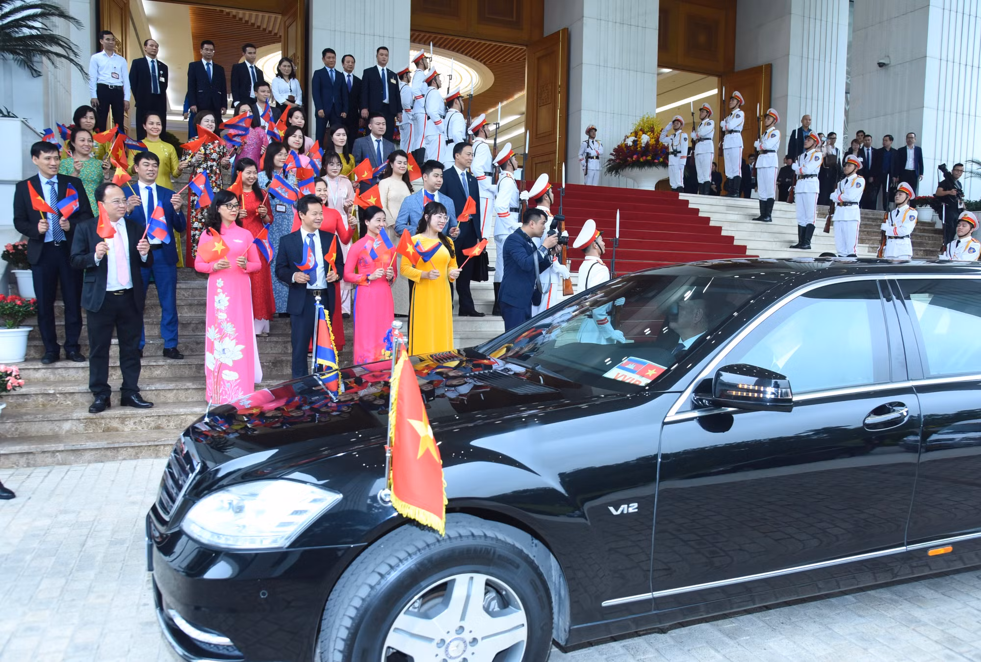 Đại diện người dân Thủ đô vẫy cờ chào đón Thủ tướng Vương quốc Campuchia Samdech Moha Bovor Thipadei Hun Manet cùng Đoàn đại biểu.