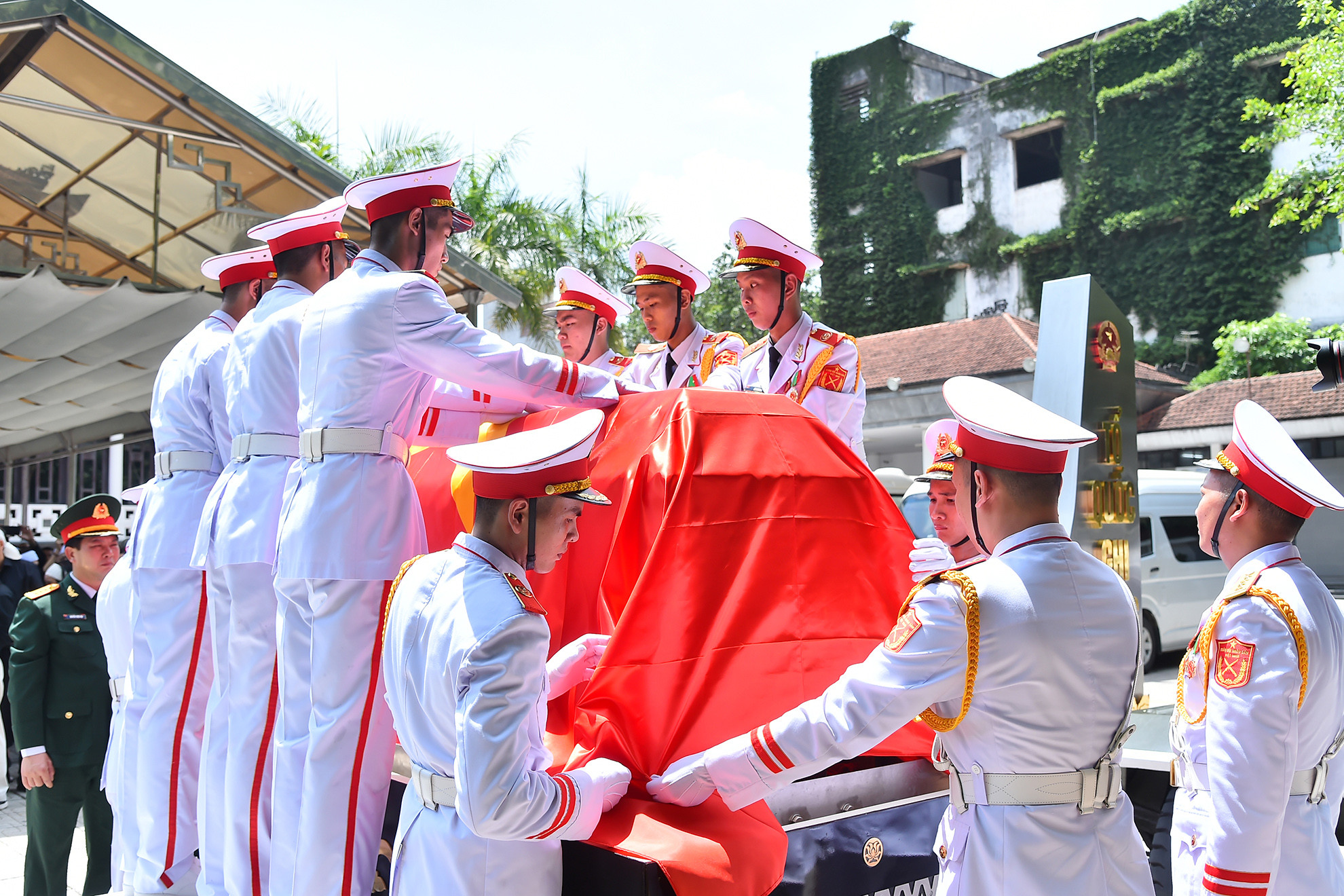 Đoàn nghi lễ quân đội phủ lá cờ Tổ quốc lên linh cữu đồng chí Nguyễn Khánh.