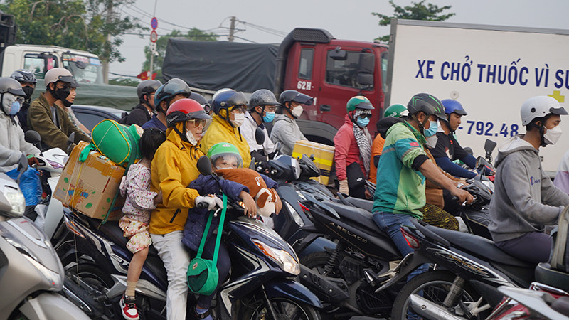 Người dân lỉnh kỉnh đồ đạc lưu thông trên đường Nguyễn Văn Linh.