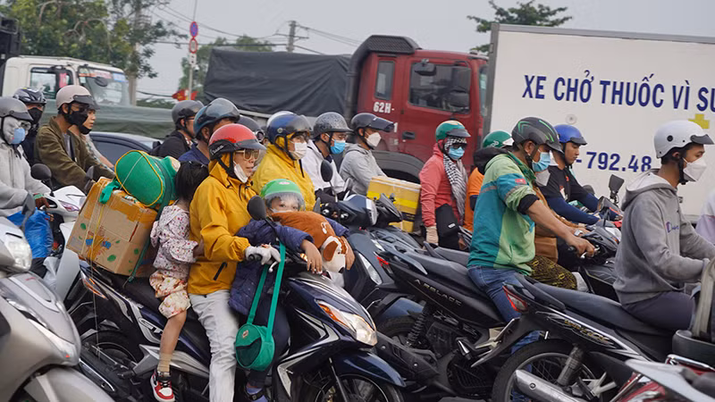 Người dân lỉnh kỉnh đồ đạc lưu thông trên đường Nguyễn Văn Linh.
