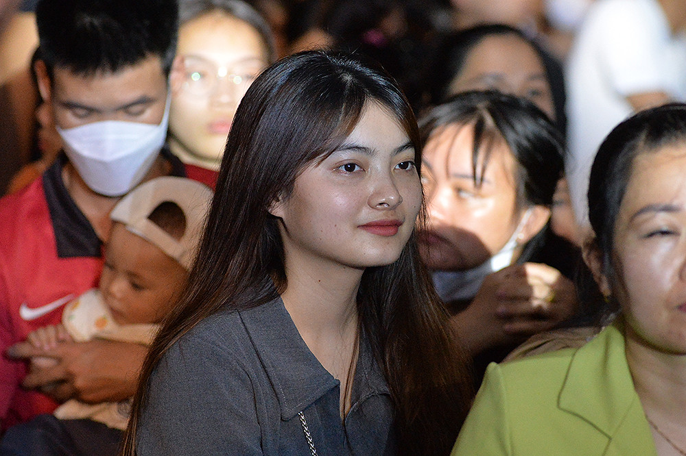 Một nữ thanh niên công nhân chăm chú theo dõi các tiết mục nghệ thuật.