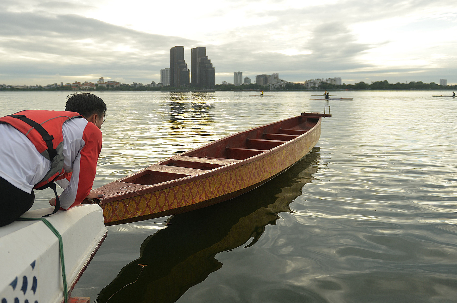 Huấn luyện viên hỗ trợ các tay chèo đưa thuyền vào vị trí.