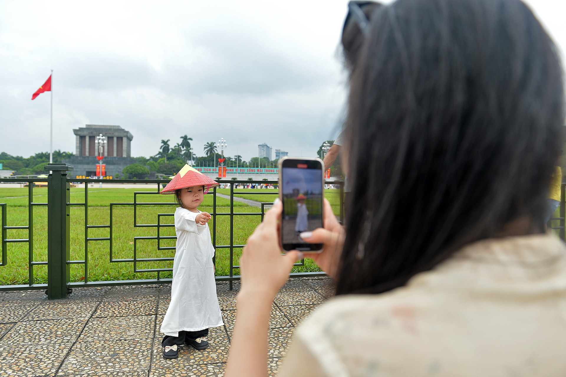 Trang phục được các bậc phụ huynh lựa chọn nhiều nhất là áo dài trắng đi kèm phụ kiện cờ đỏ sao vàng như mũ, nón, cờ cầm tay. Trang phục được các bậc phụ huynh lựa chọn nhiều nhất là áo dài trắng đi kèm phụ kiện cờ đỏ sao vàng như mũ, nón, cờ cầm tay.