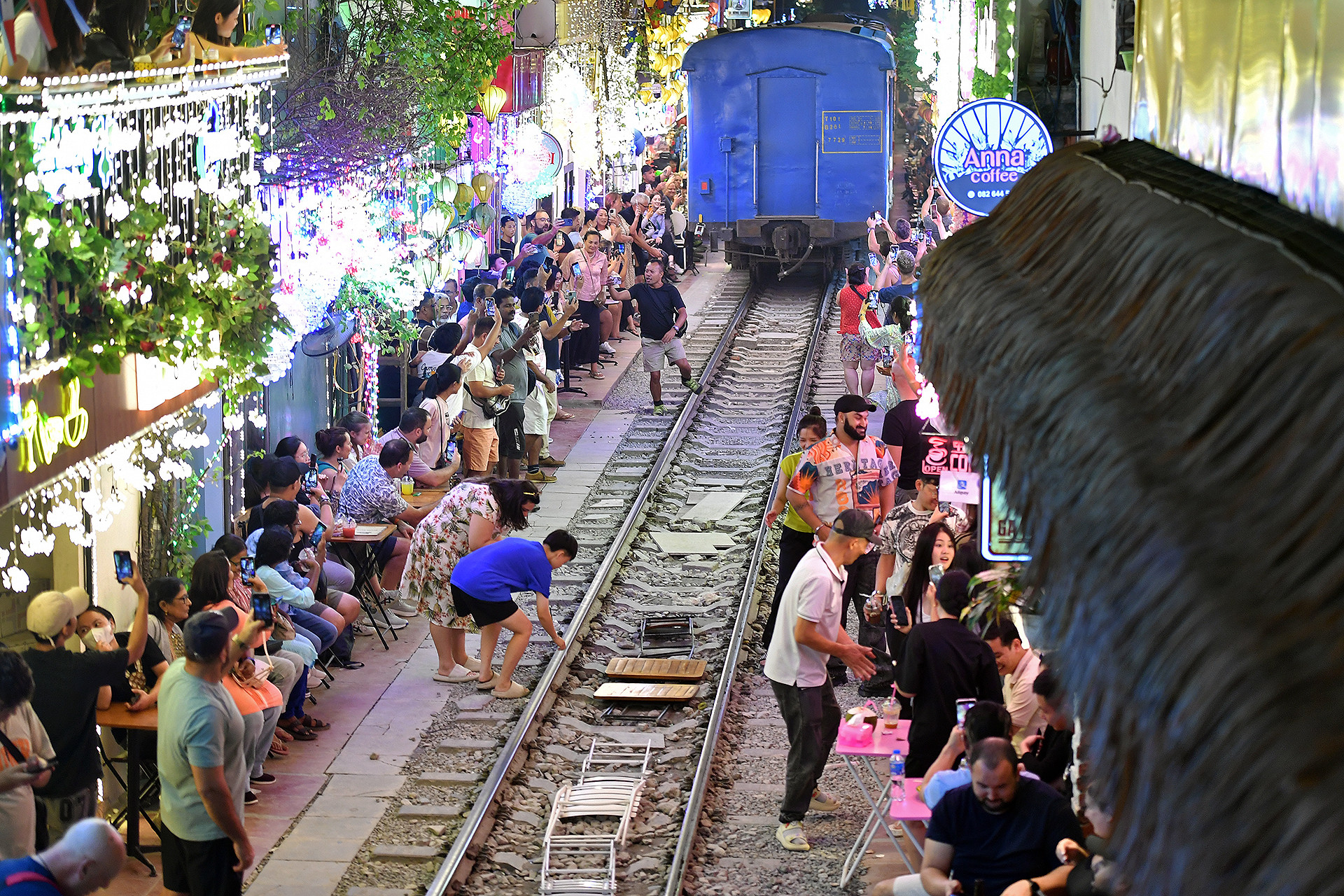 Không thể phủ nhận sự tồn tại của những dịch vụ như "cà phê đường tàu" dù nguy hiểm nhưng lại góp phần không nhỏ tạo nên một cảm giác thân thiện, góp phần quảng bá sự sáng tạo của du lịch Việt Nam đến với du khách thập phương. Trong ảnh là đông đảo khách du lịch tỏ ra hào hứng với những thước phim cũng như các món kỷ vật đặc biệt vừa có được sau khi đoàn tàu đi qua ở khu vực Phùng Hưng - Trần Phú.