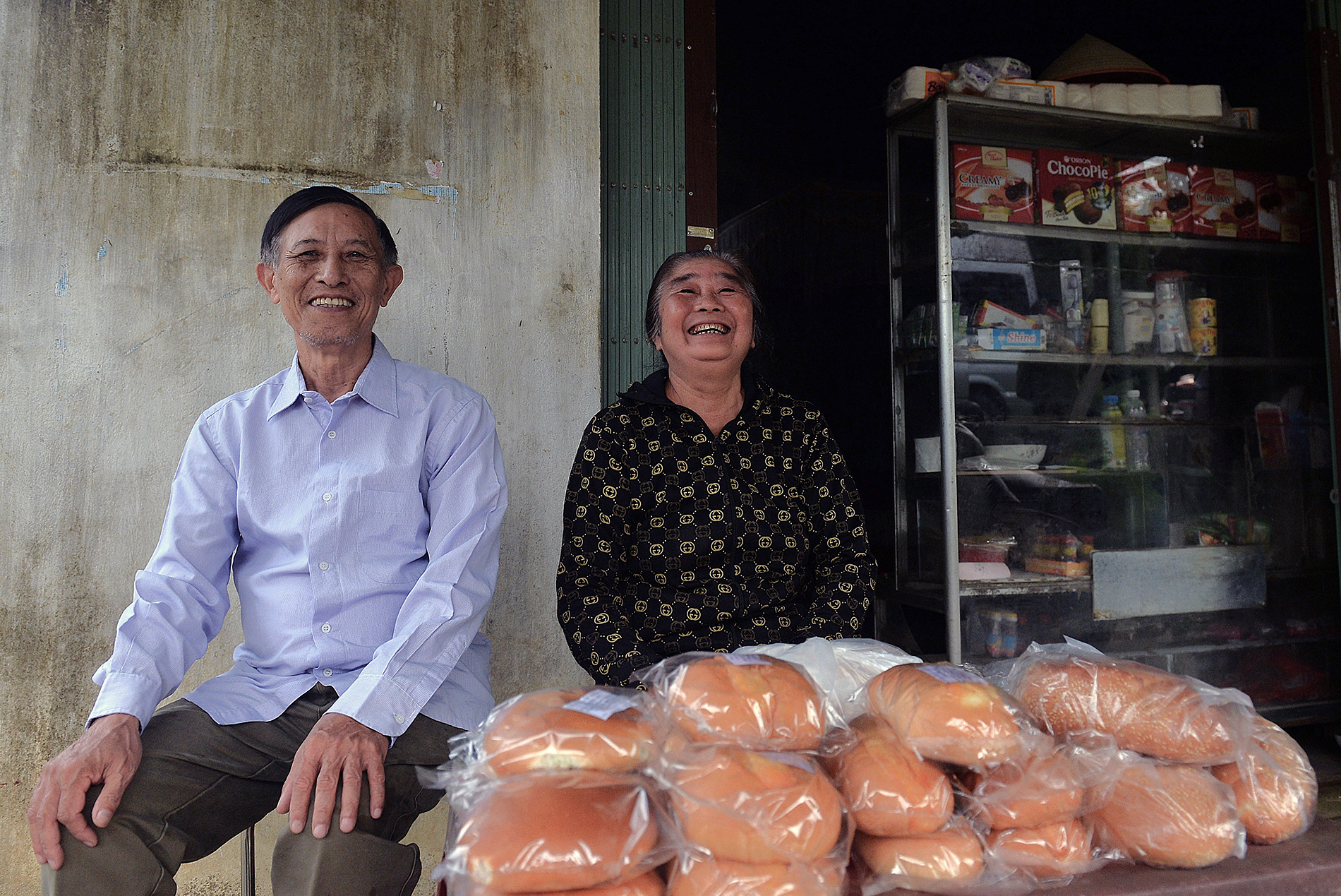 Vợ chồng ông Nguyễn Thanh Đức bên gian hàng tạp hóa trước cửa nhà.