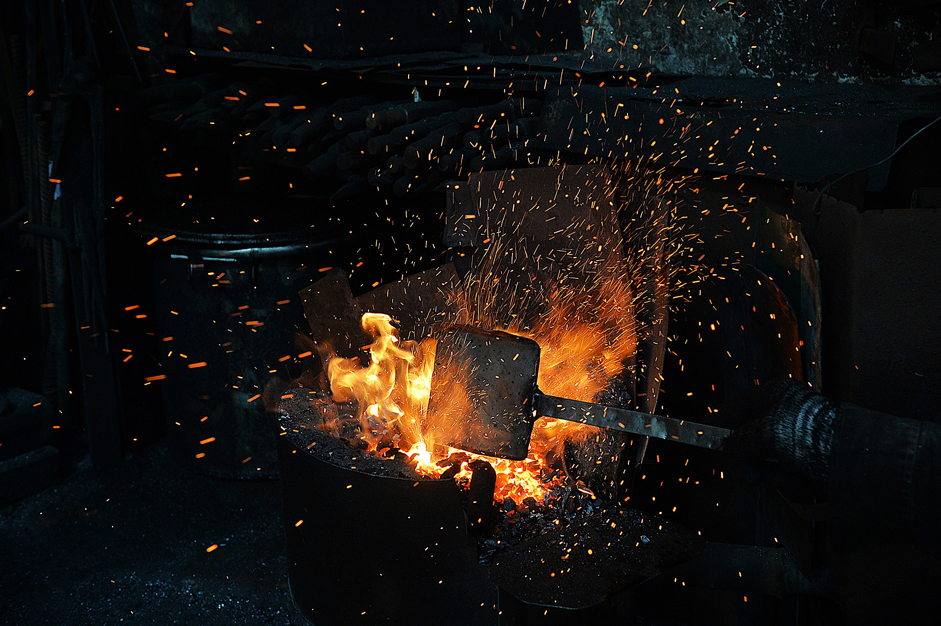 Sau mỗi đợt rèn, ông Hùng lại cho thêm than vào bếp để gia nhiệt.