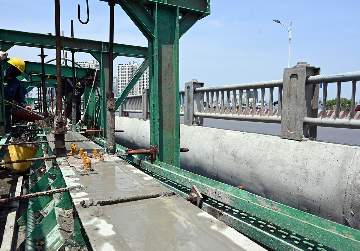Công nhân nhà thầu Trung Chính tiến hành đổ bê-tông hạng mục trụ lan can trên bề mặt cầu. Công nhân nhà thầu Trung Chính tiến hành đổ bê-tông hạng mục trụ lan can trên bề mặt cầu.