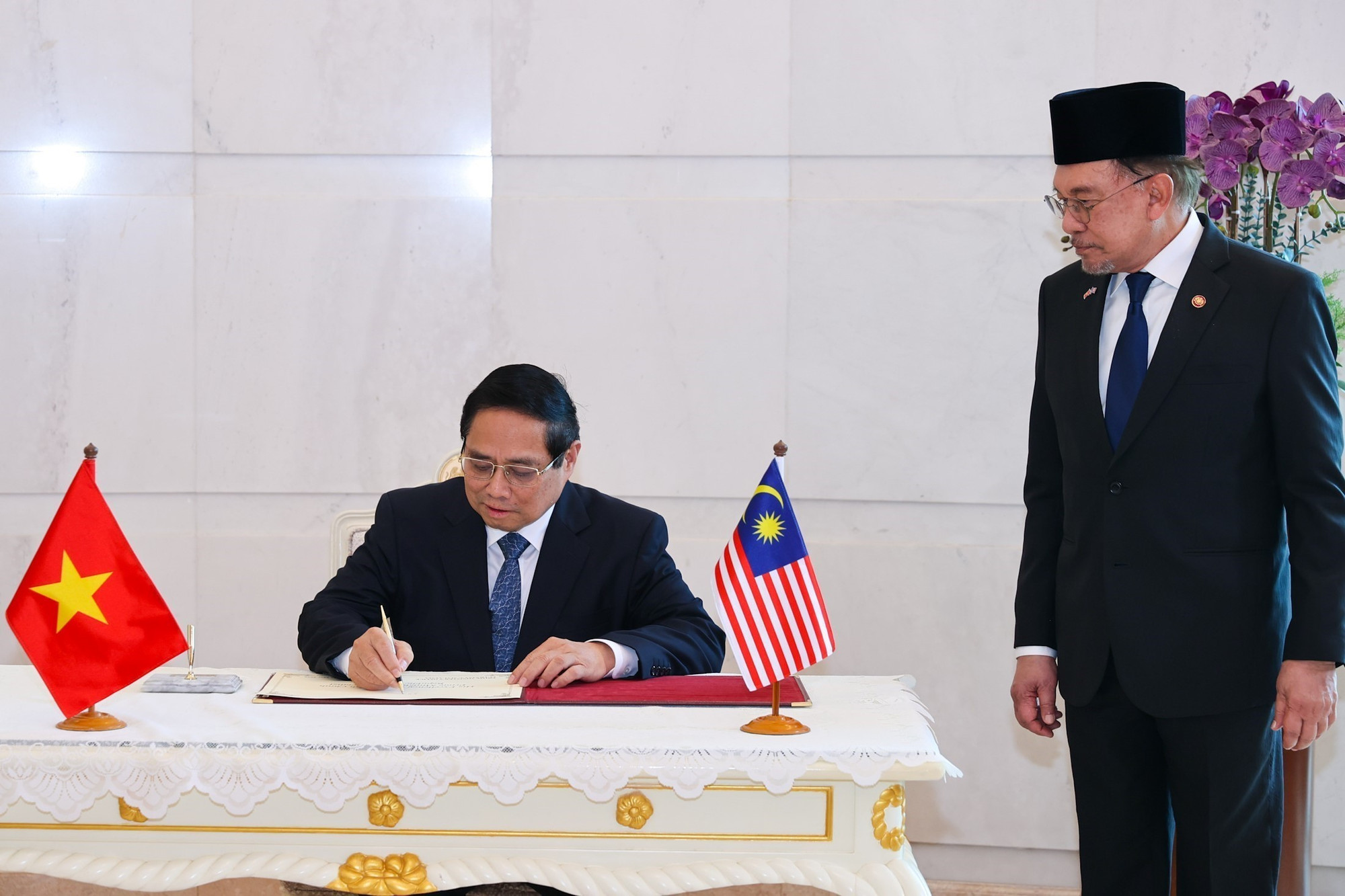 Thủ tướng Phạm Minh Chính ký sổ lưu niệm tại Phủ Thủ tướng Malaysia. (Ảnh: TTXVN)