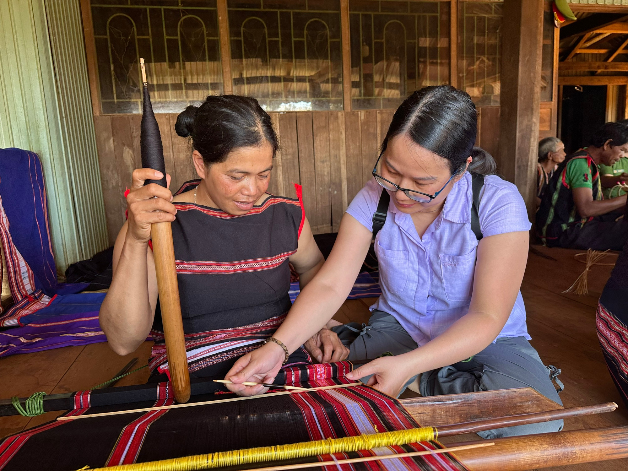 Hướng dẫn du khách trải nghiệm dệt vải. (Ảnh THI PHONG)