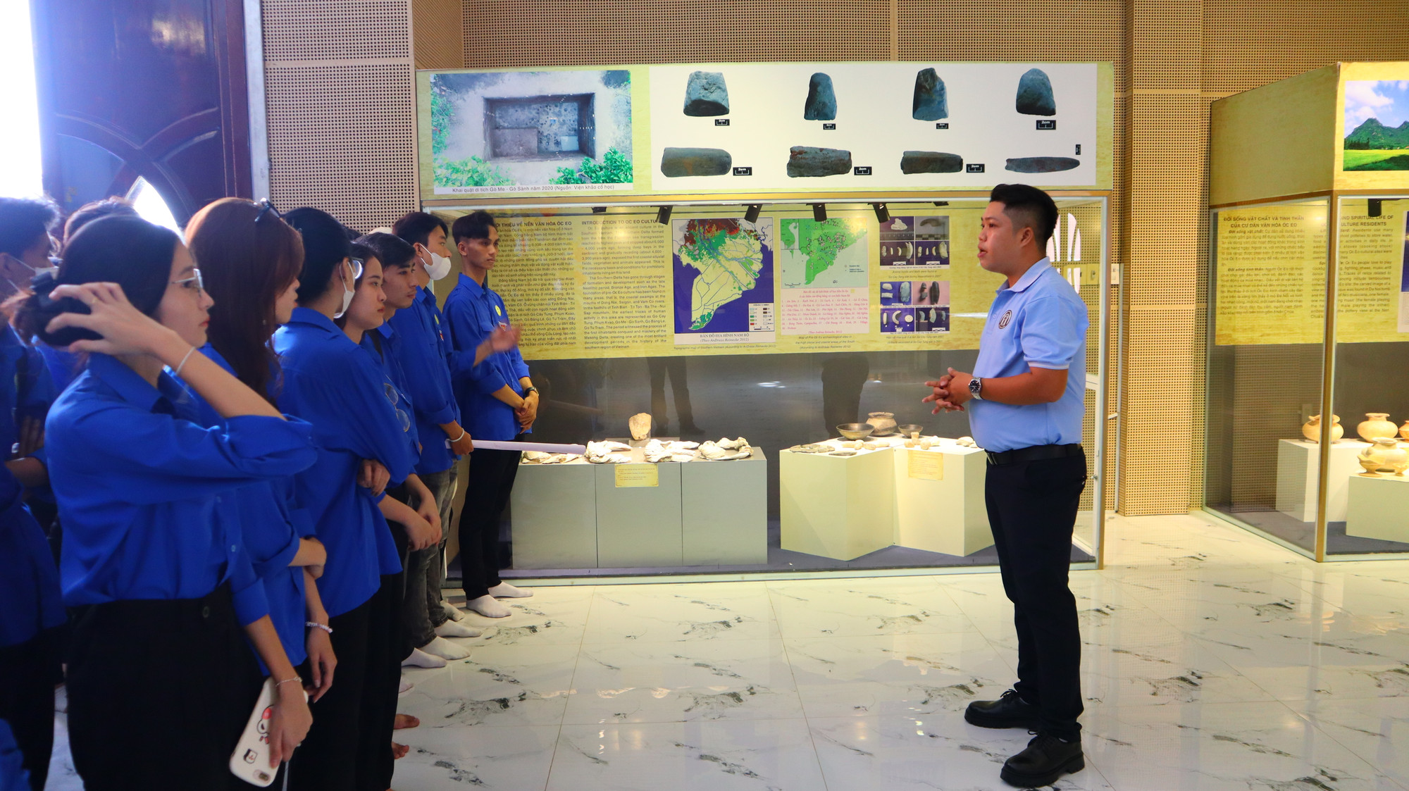 Trương Minh Thuận đang thuyết minh hướng dẫn cho các bạn trẻ đến tham quan Nhà trưng bày văn hóa Óc Eo.