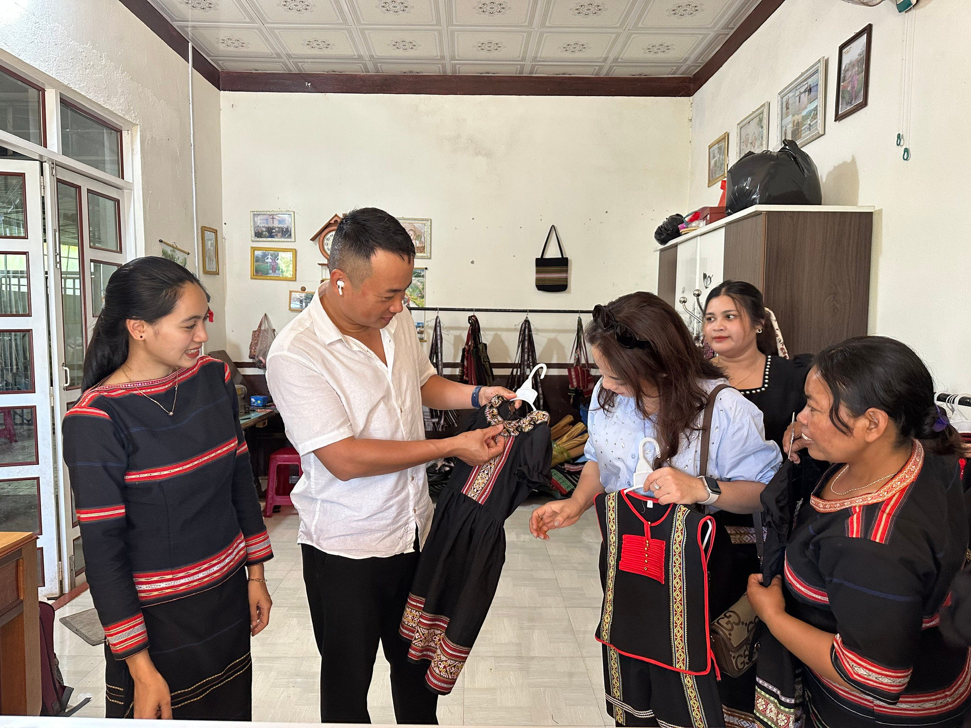 Du khách thích thú với các sản phẩm dệt thổ cẩm truyền thống của đồng bào Gia Rai. (Ảnh THI PHONG)