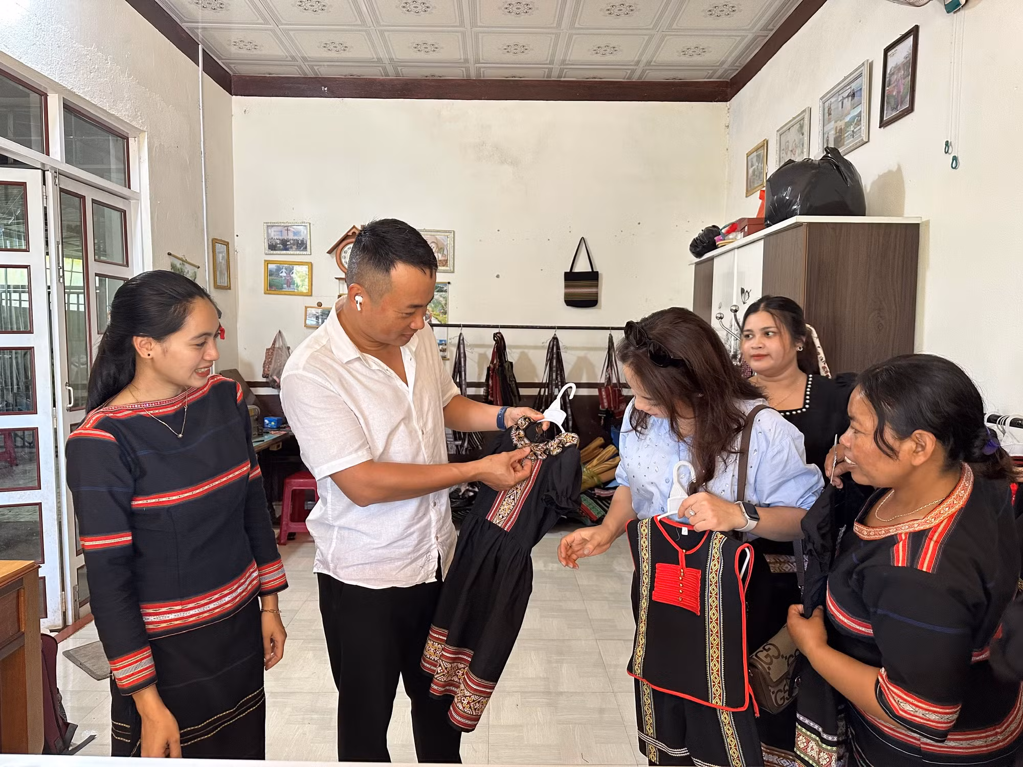 Du khách thích thú với các sản phẩm dệt thổ cẩm truyền thống của đồng bào Gia Rai. (Ảnh THI PHONG)