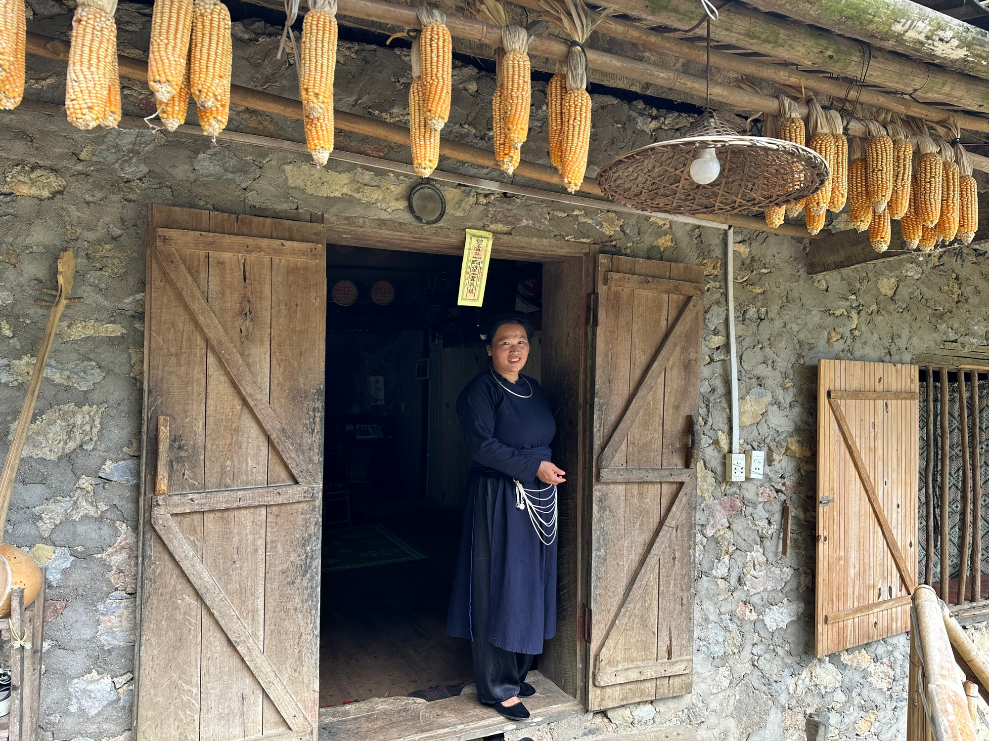 Chị Mạc Thị Khon trước ngôi nhà truyền thống của gia đình được cải tạo làm homestay. (Ảnh: THI PHONG)