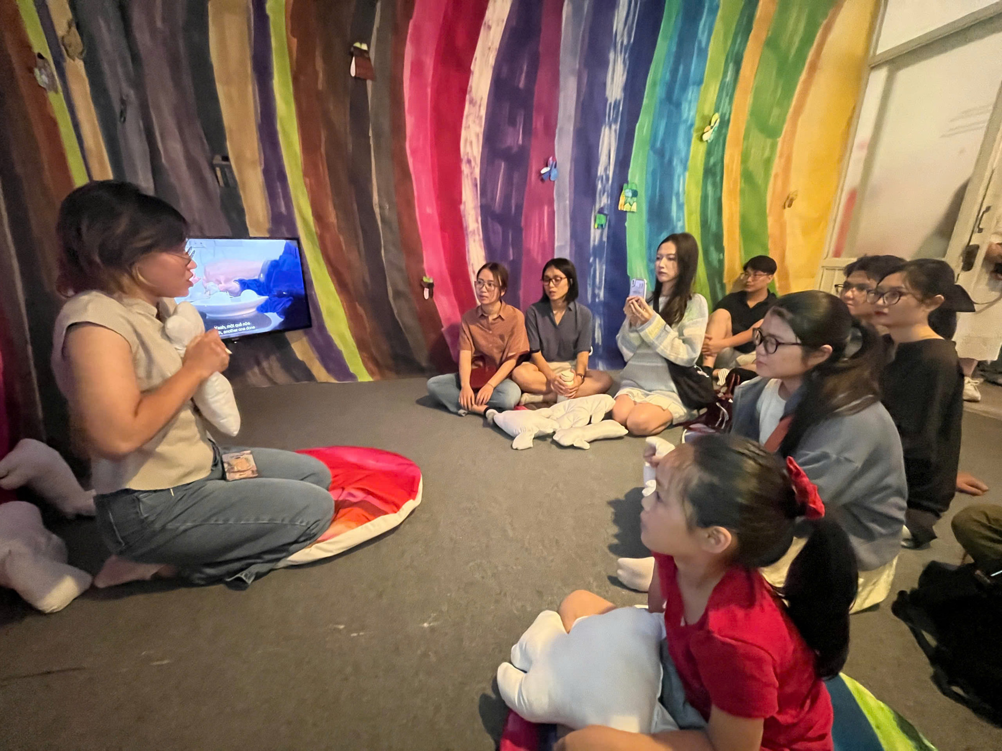 Khách tham quan được điều phối viên giới thiệu về các tác phẩm cùng những câu chuyện đặc biệt của các em nhỏ tự kỷ.