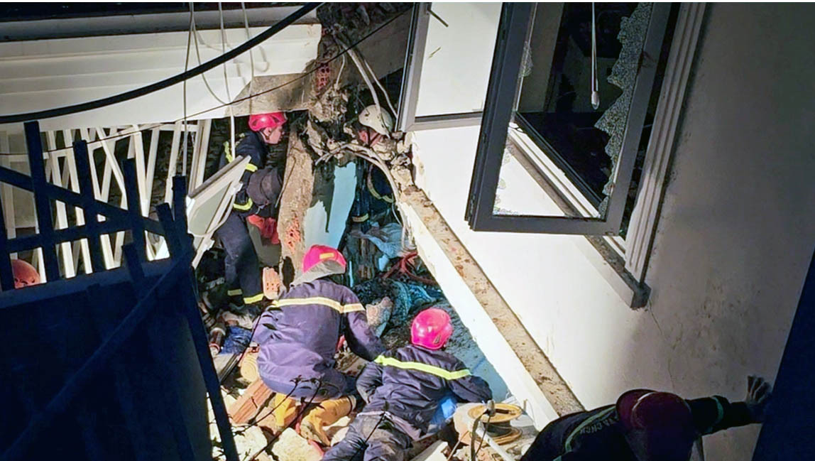 Lực lượng chức năng giải cứu những nạn nhân mắc kẹt trong ngôi nhà bị xô lệch do vụ sạt lở lúc rạng sáng.