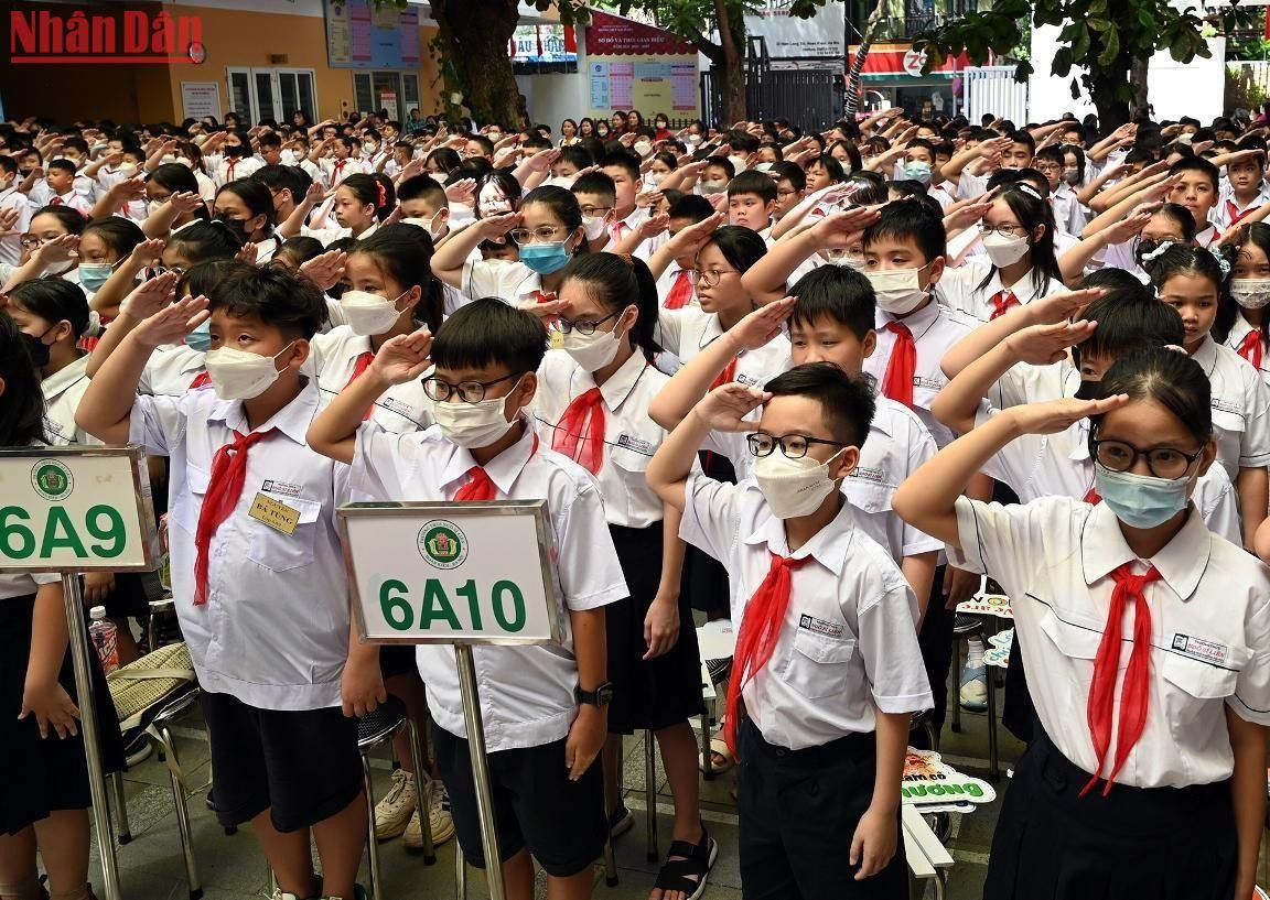 Các em học sinh thực hiện nghi thức chào cờ tại lễ khai giảng.