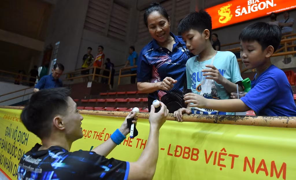 Tay vợt Nguyễn Anh Tú ký tặng bóng bàn cho các cổ động viên.