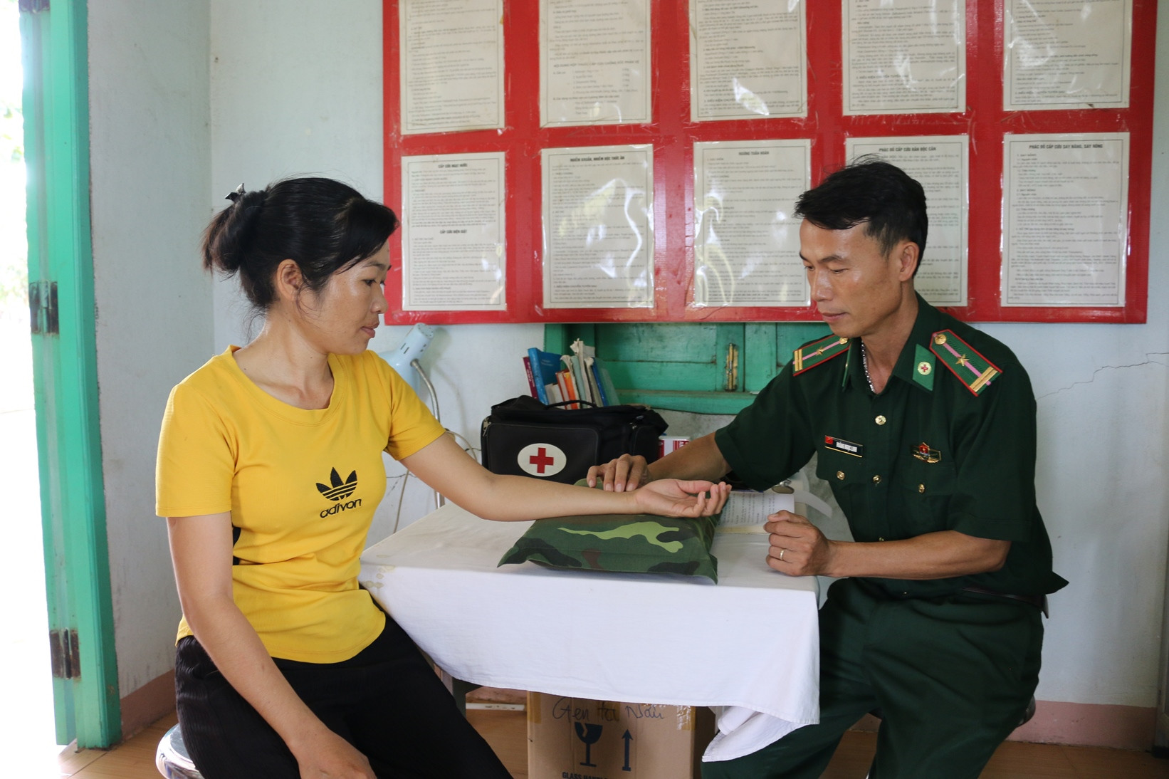Thiếu tá, bác sĩ Hoàng Ngọc Linh khám bệnh cho người dân vùng biên. (Ảnh: KIM NGÂN)