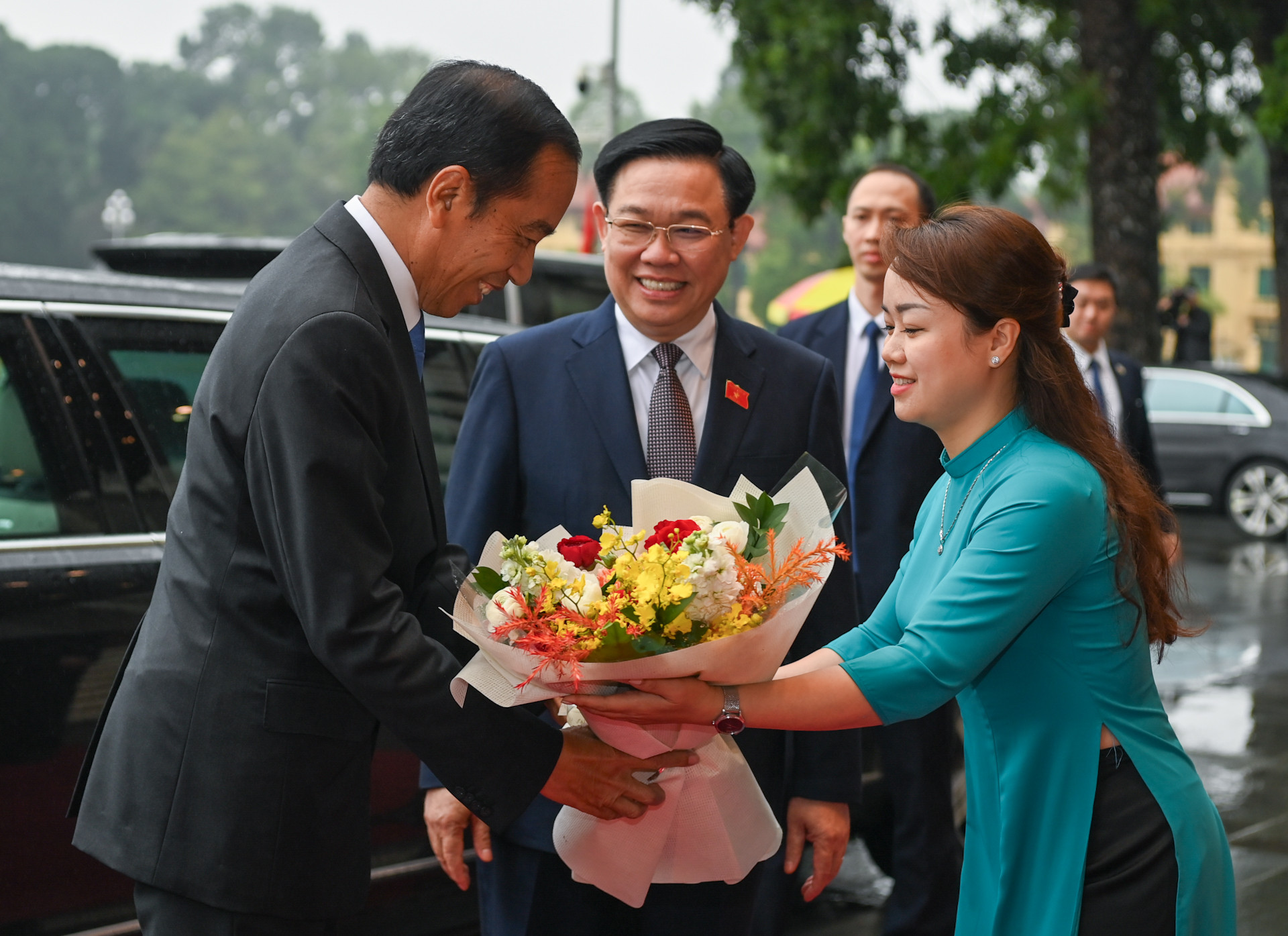 Nhân viên Văn phòng Quốc hội tặng hoa chào mừng Tổng thống Indonesia Joko Widodo.