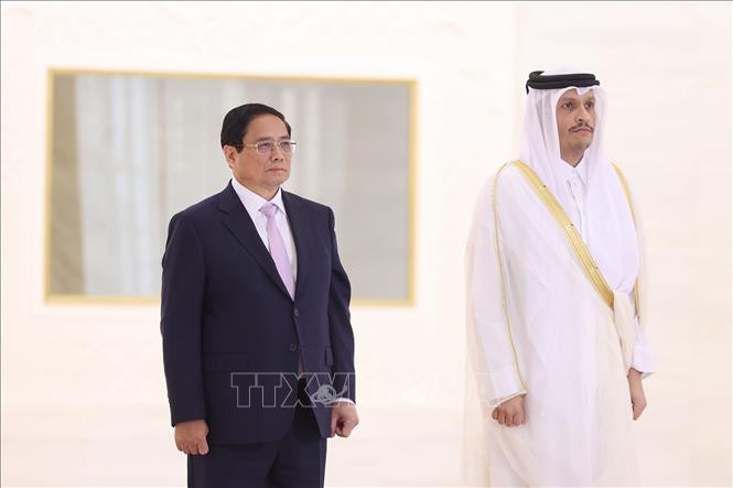 Thủ tướng Phạm Minh Chính và Thủ tướng Nhà nước Qatar Sheikh Mohammed bin Abdulrahman bin Jasim Al-Thani nghe quân nhạc cử Quốc thiều hai nước. (Ảnh: Dương Giang/TTXVN)