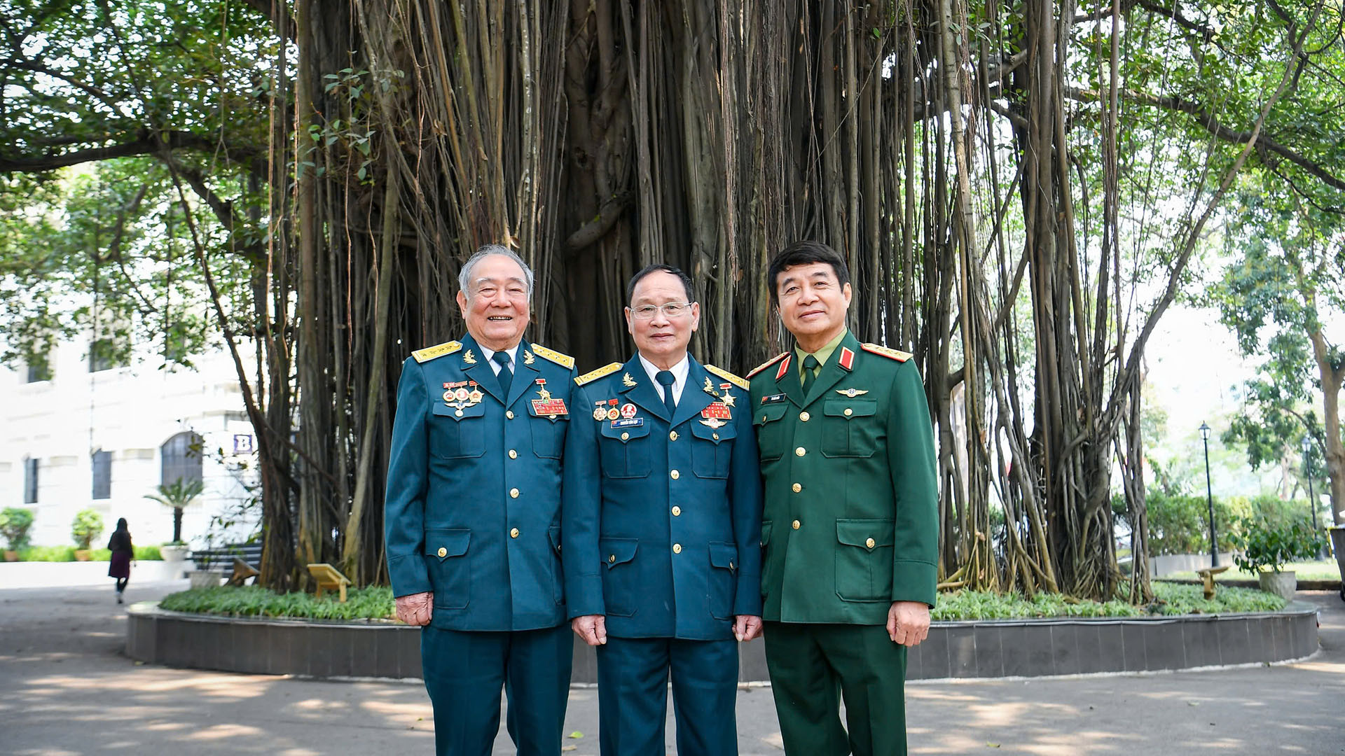 Các đại biểu chụp ảnh lưu niệm bên gốc đa trong khuôn viên toàn soạn Báo Nhân Dân.