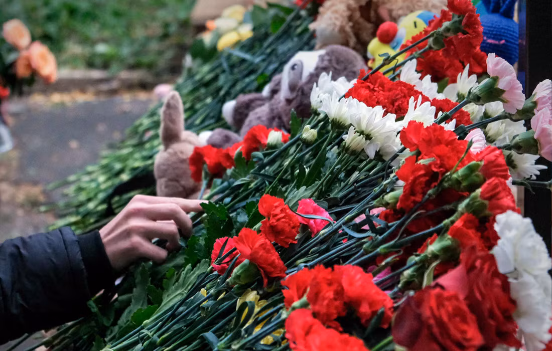 Người dân đặt hoa tưởng niệm các nạn nhân vụ xả súng tại trường học số 88 ở Izhevsk khiến 19 người chết, 23 người bị thương. Ảnh: TASS