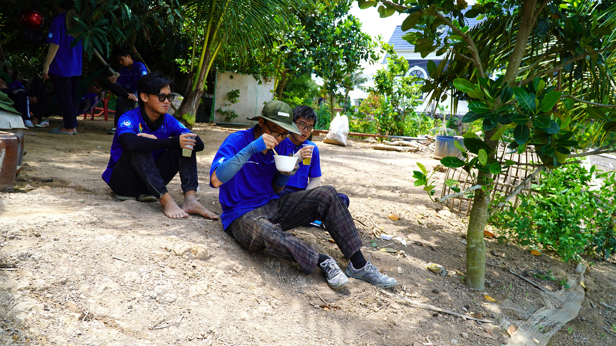 Chiến sĩ tình nguyện dùng bữa trưa trong sân nhà dân.