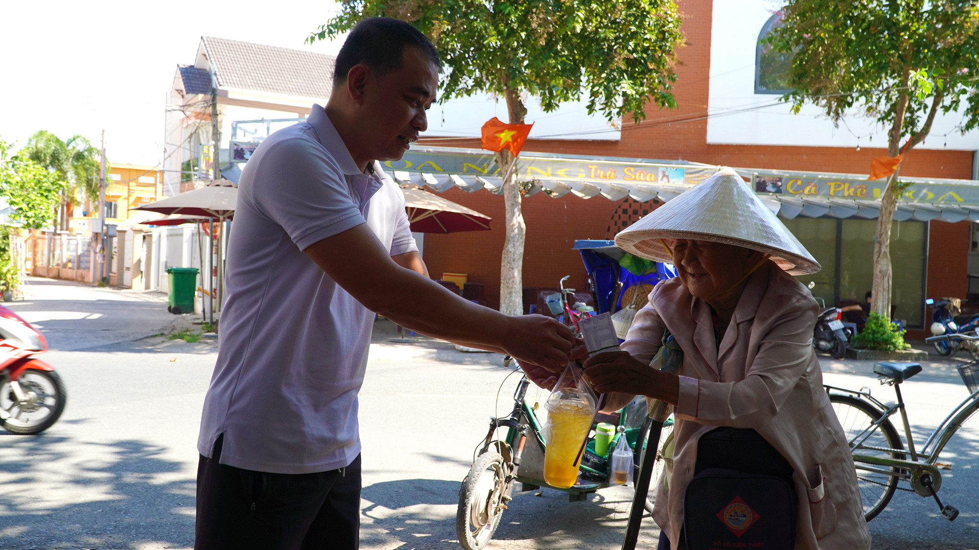 Anh Trương Công Thiện mang cà-phê treo hỗ trợ cụ bán vé số.