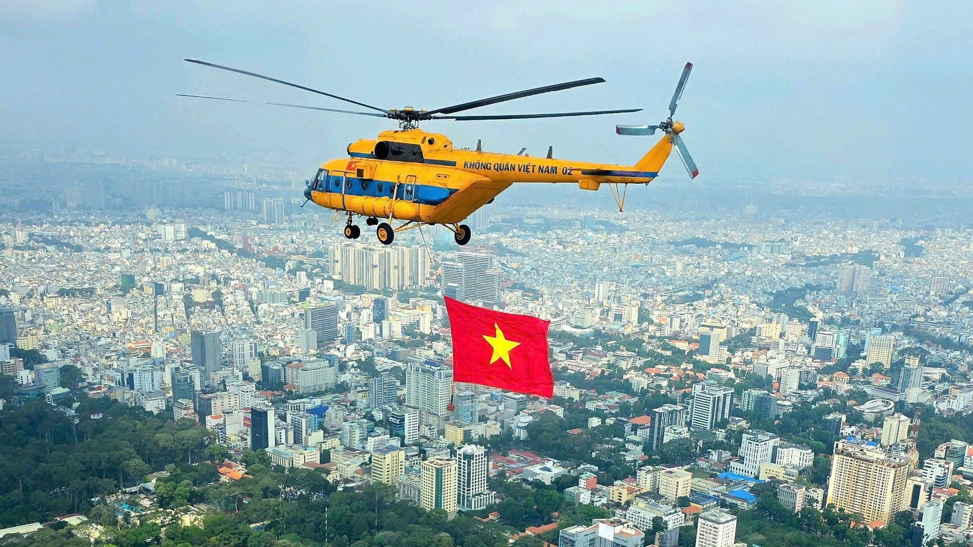 Máy bay trực thăng kéo cờ Tổ quốc luyện tập trên bầu trời Thành phố Hồ Chí Minh.