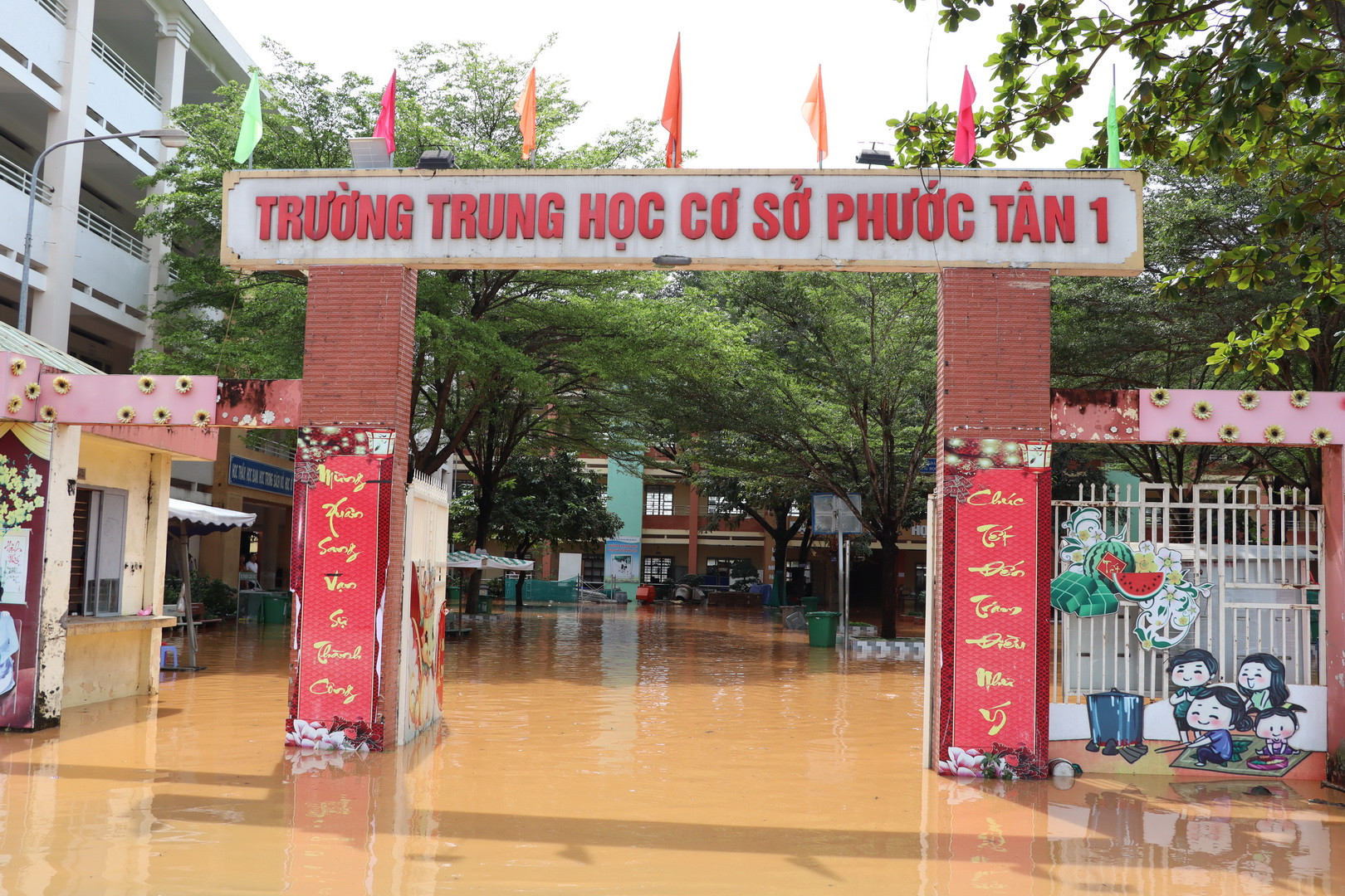 Nước lũ tràn vào trường buộc Ban Giám hiệu Trường trung học cơ sở Phước Tân 1 cho hơn 2.600 học sinh nghỉ học.