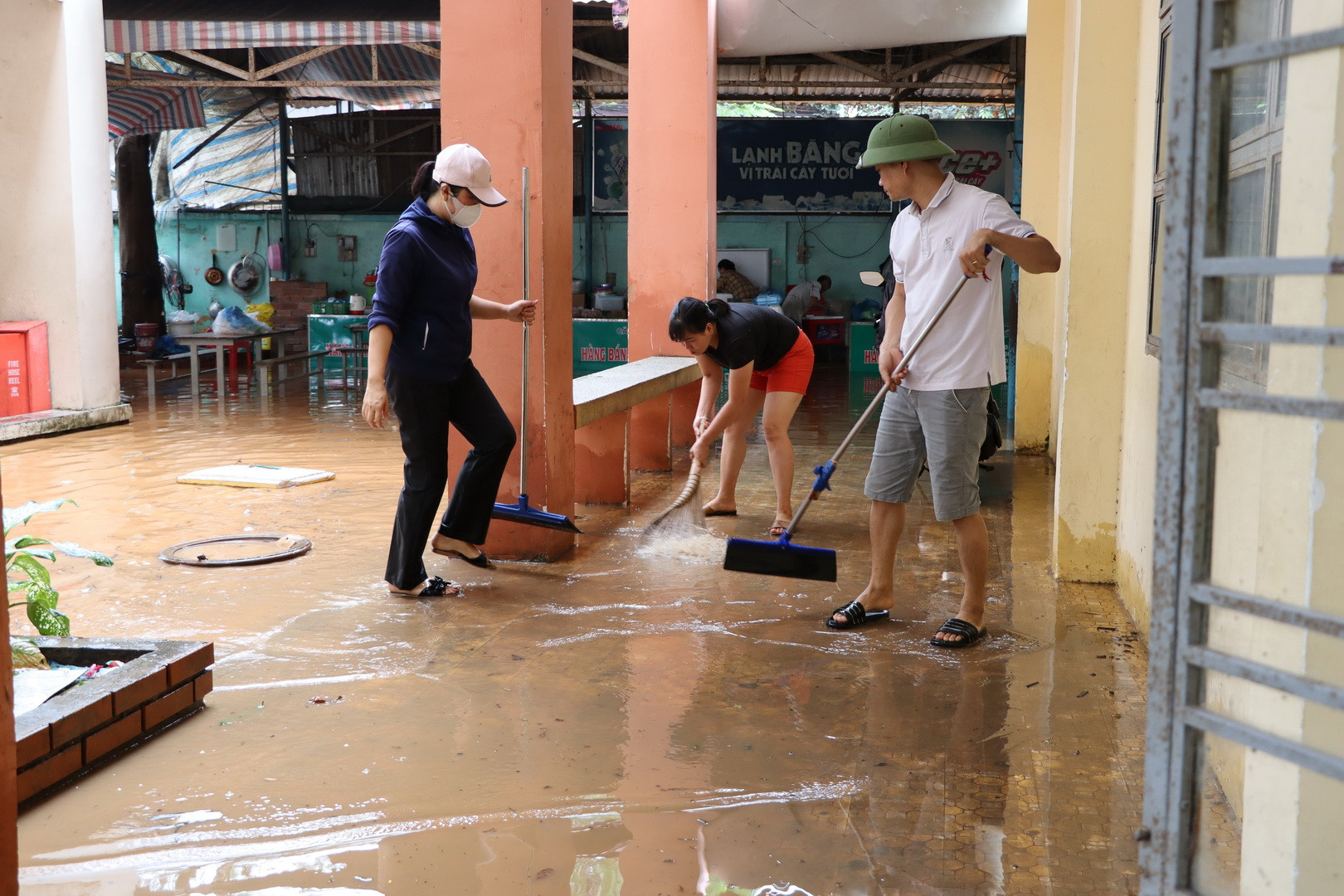 Các thầy cô giáo Trường trung học cơ sở Phước Tân 1 tiến hành dọn dẹp khi nước lũ rút dần.