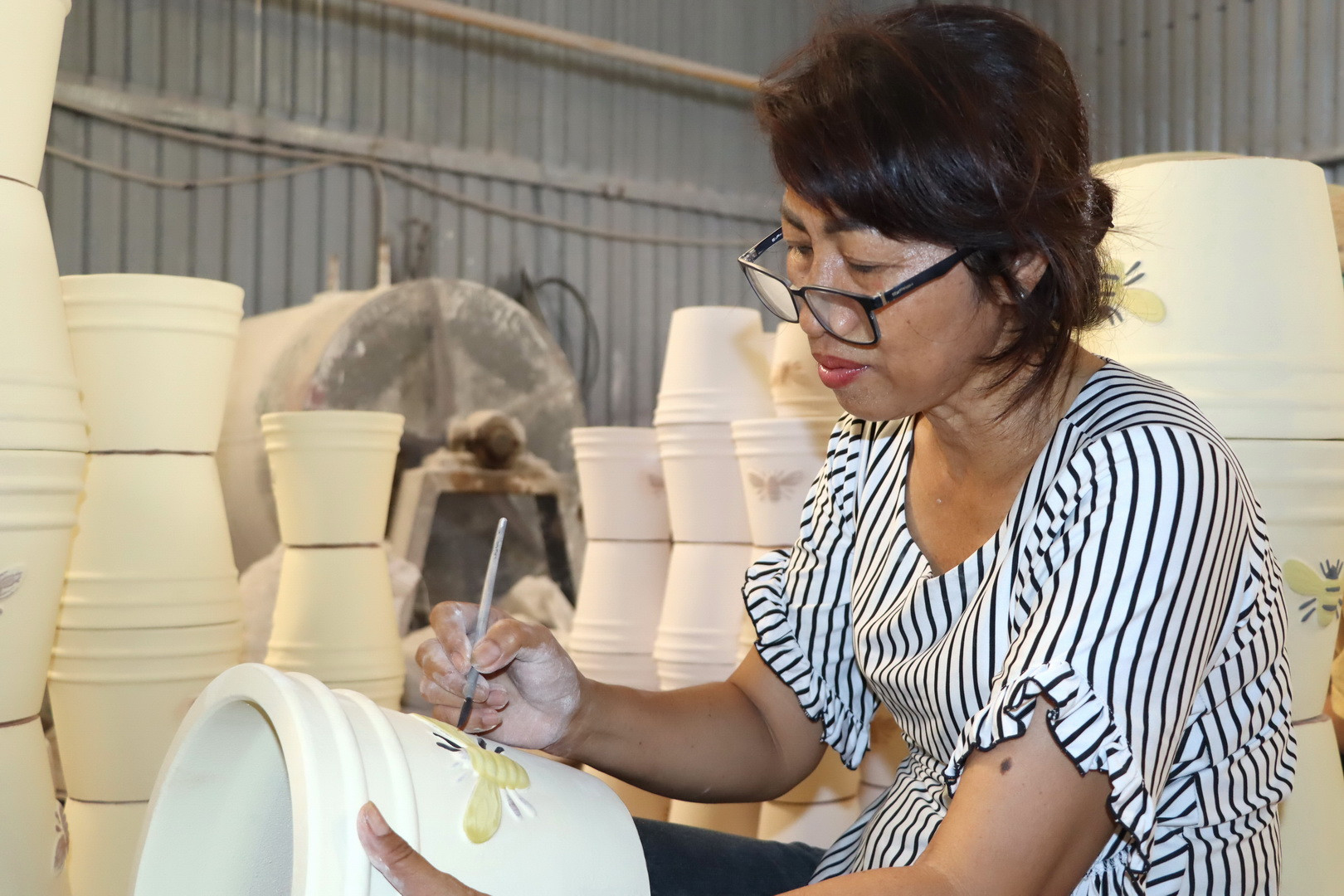 Thợ gốm có nhiều năm kinh nghiệm đang chạm khắc hoa văn lên sản phẩm. Thợ gốm có nhiều năm kinh nghiệm đang chạm khắc hoa văn lên sản phẩm.