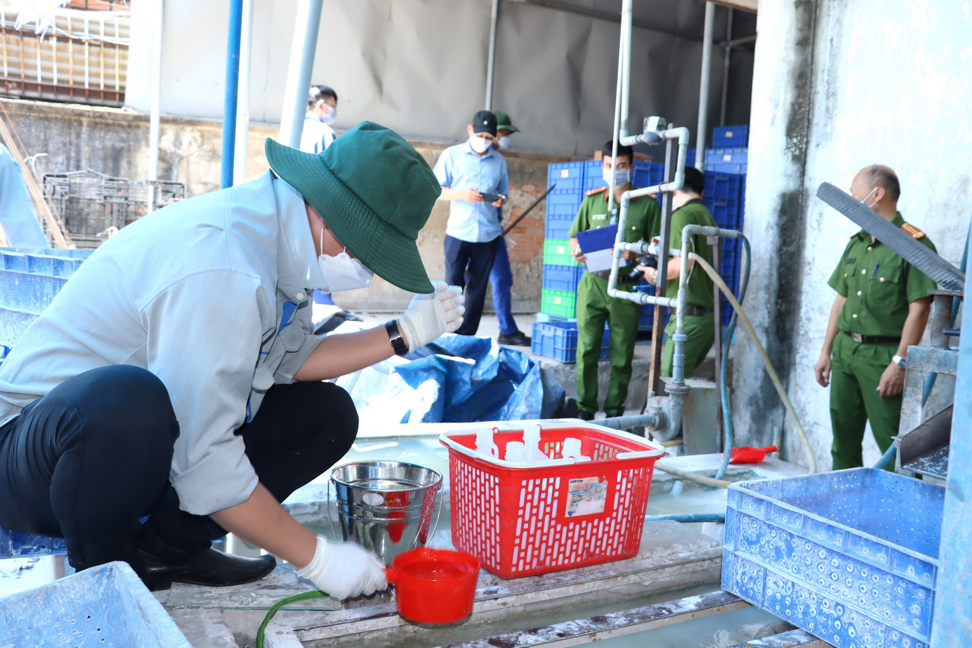 Cơ quan chức năng lấy mẫu trong vụ bắt quả tang Xí nghiệp bóng đèn Điện Quang gây ô nhiễm môi trường.