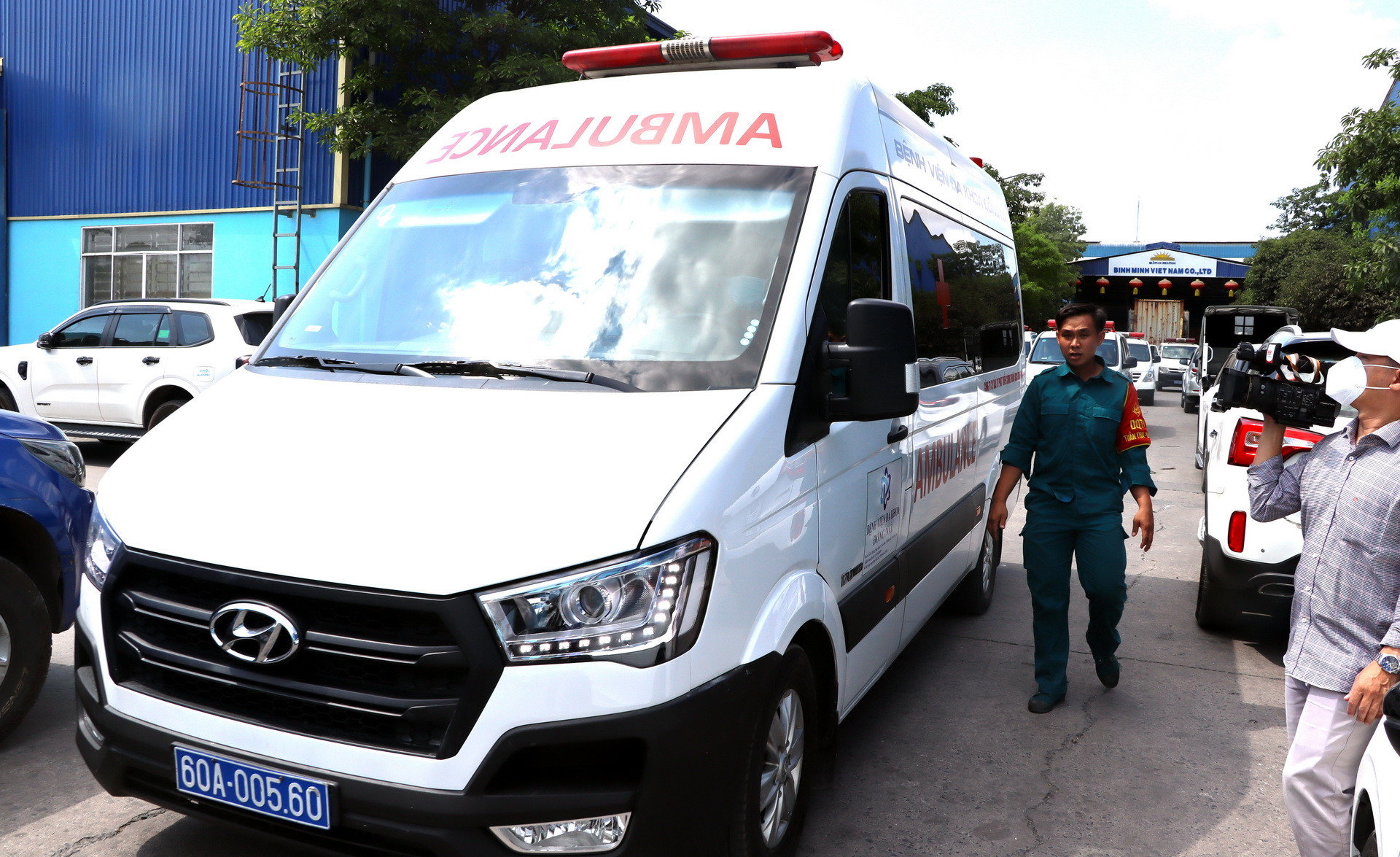 Xe cứu thương chở người từ bên trong Công ty Trách nhiệm hữu hạn gỗ Bình Minh đến bệnh viện.