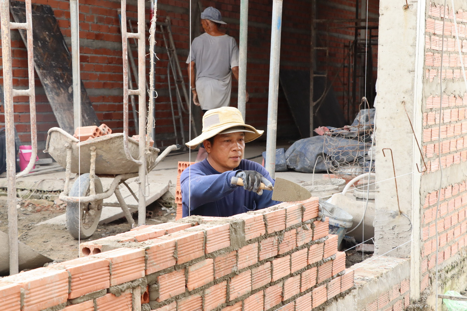 Công nhân đang xây dựng một ngôi nhà của người dân.