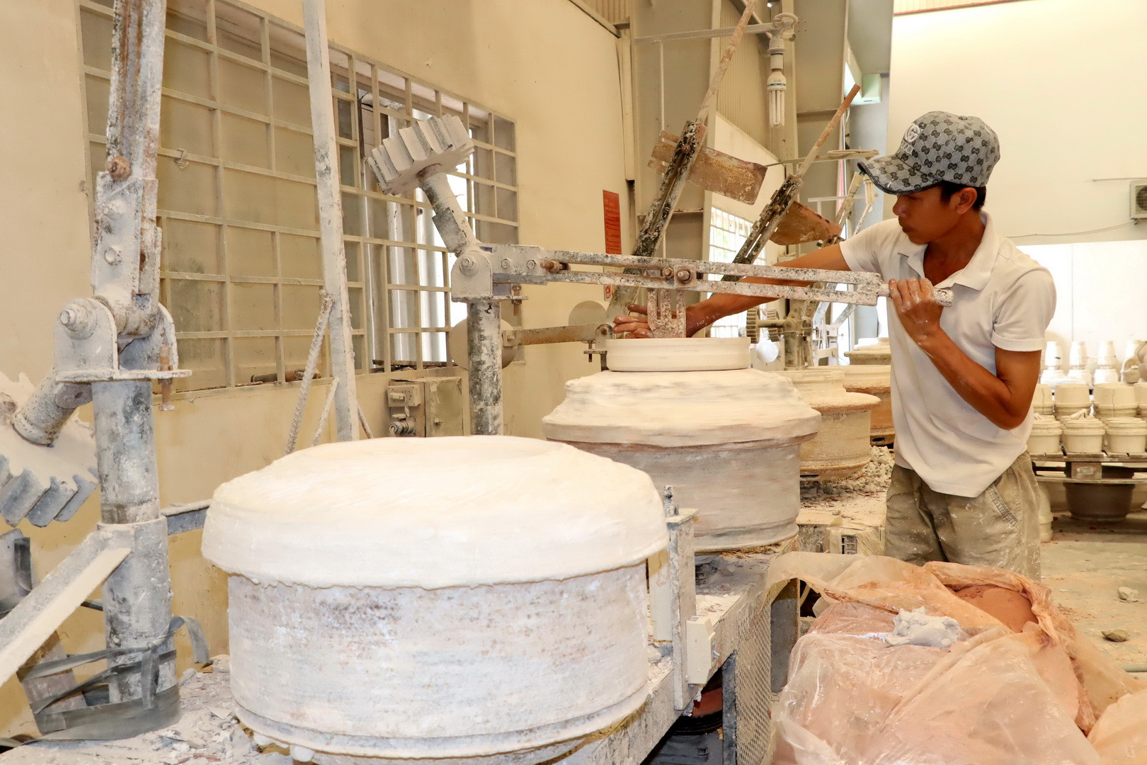 Thợ gốm thực hiện công đoạn tạo hình sản phẩm. Thợ gốm thực hiện công đoạn tạo hình sản phẩm.